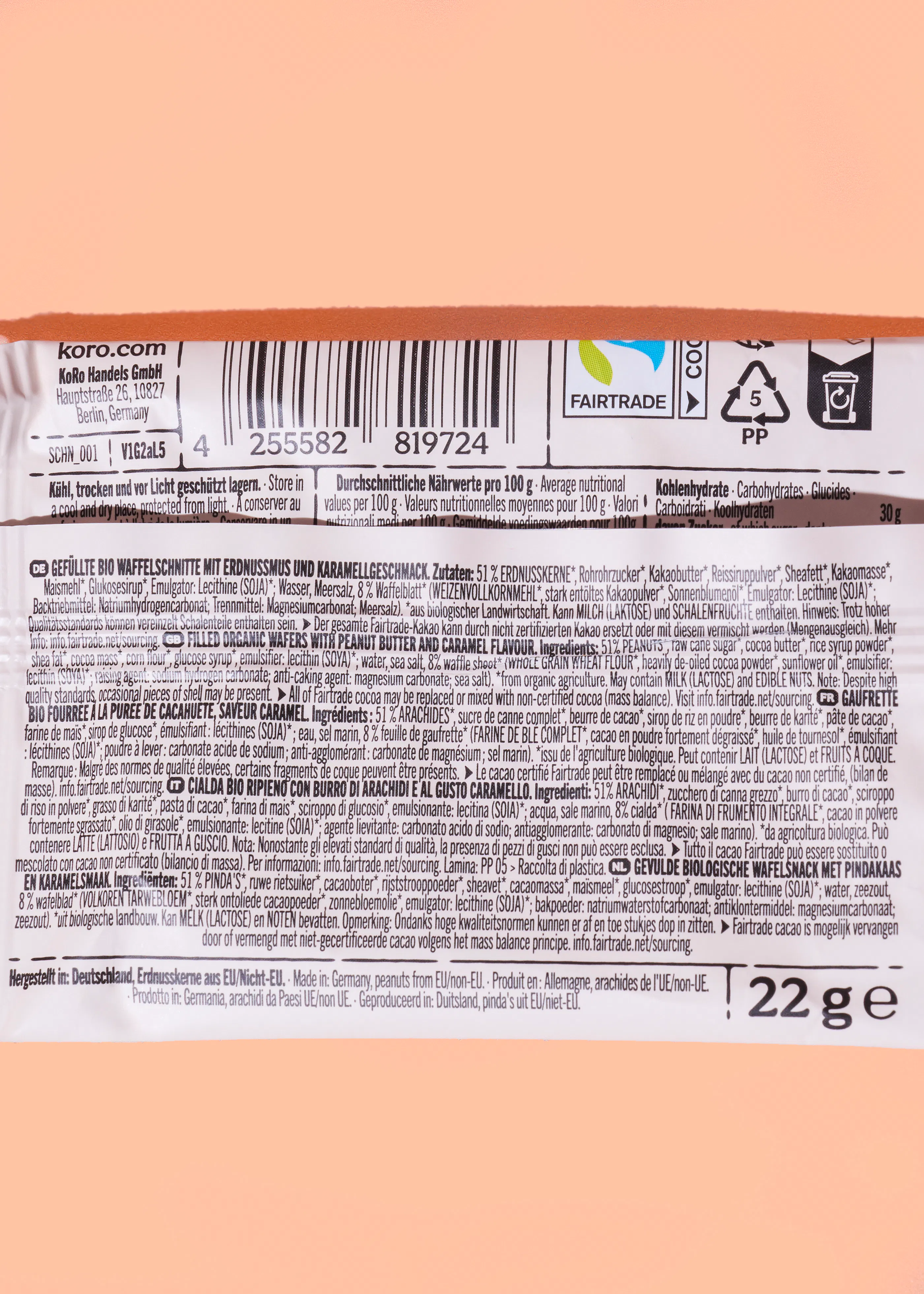 ein produktetikett einer koro bio-waffelschnitte mit erdnussmus und karamellgeschmack, das zutaten, nährwertangaben und fairtrade-informationen in mehreren sprachen darstellt.