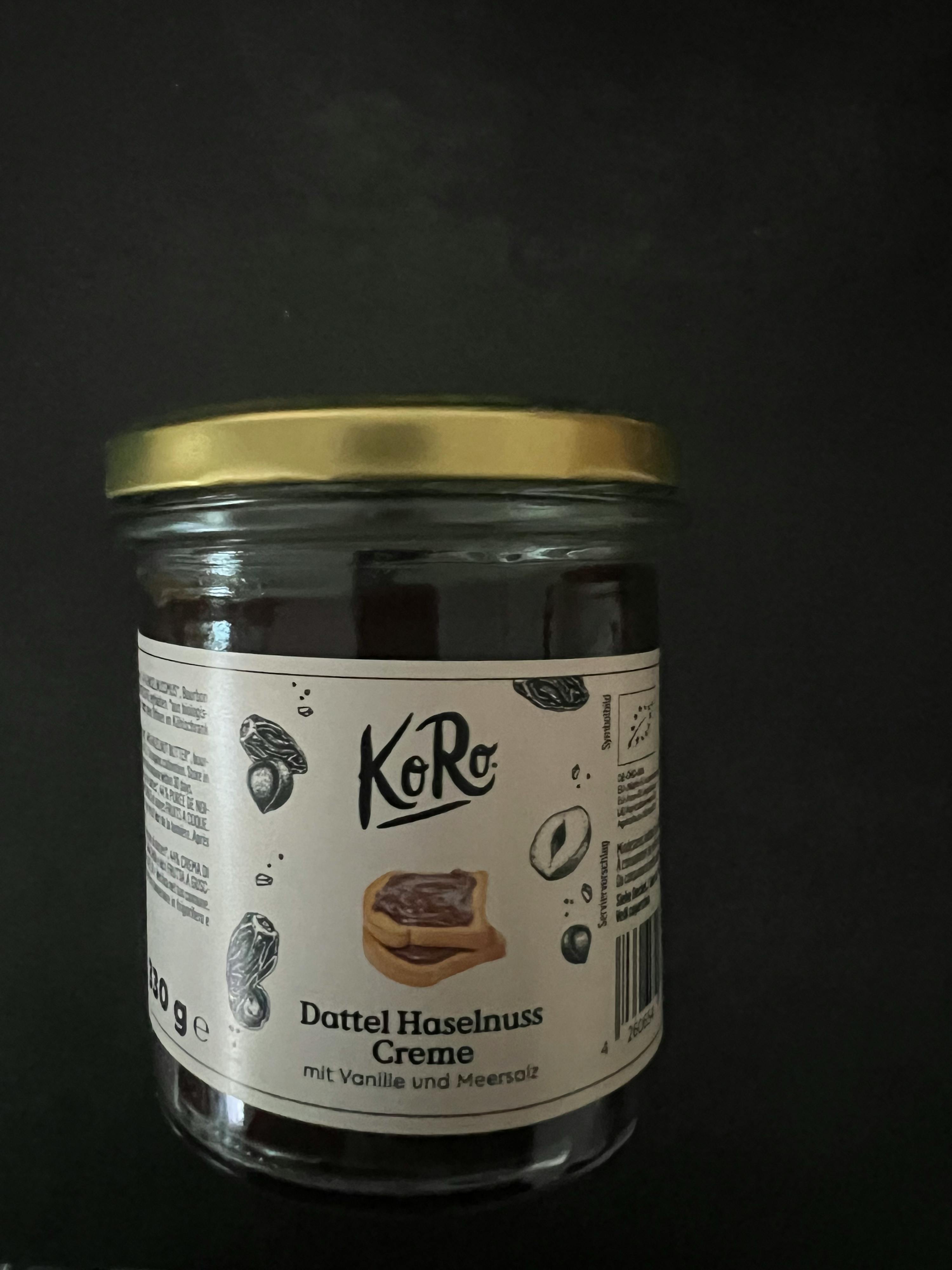 ein Glas dattel-Haselnuss-Creme steht auf einem schwarzen Tisch