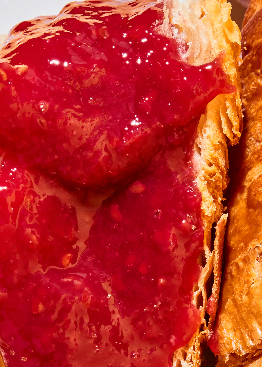 un gros plan d' un croissant avec de la confiture sur le dessus