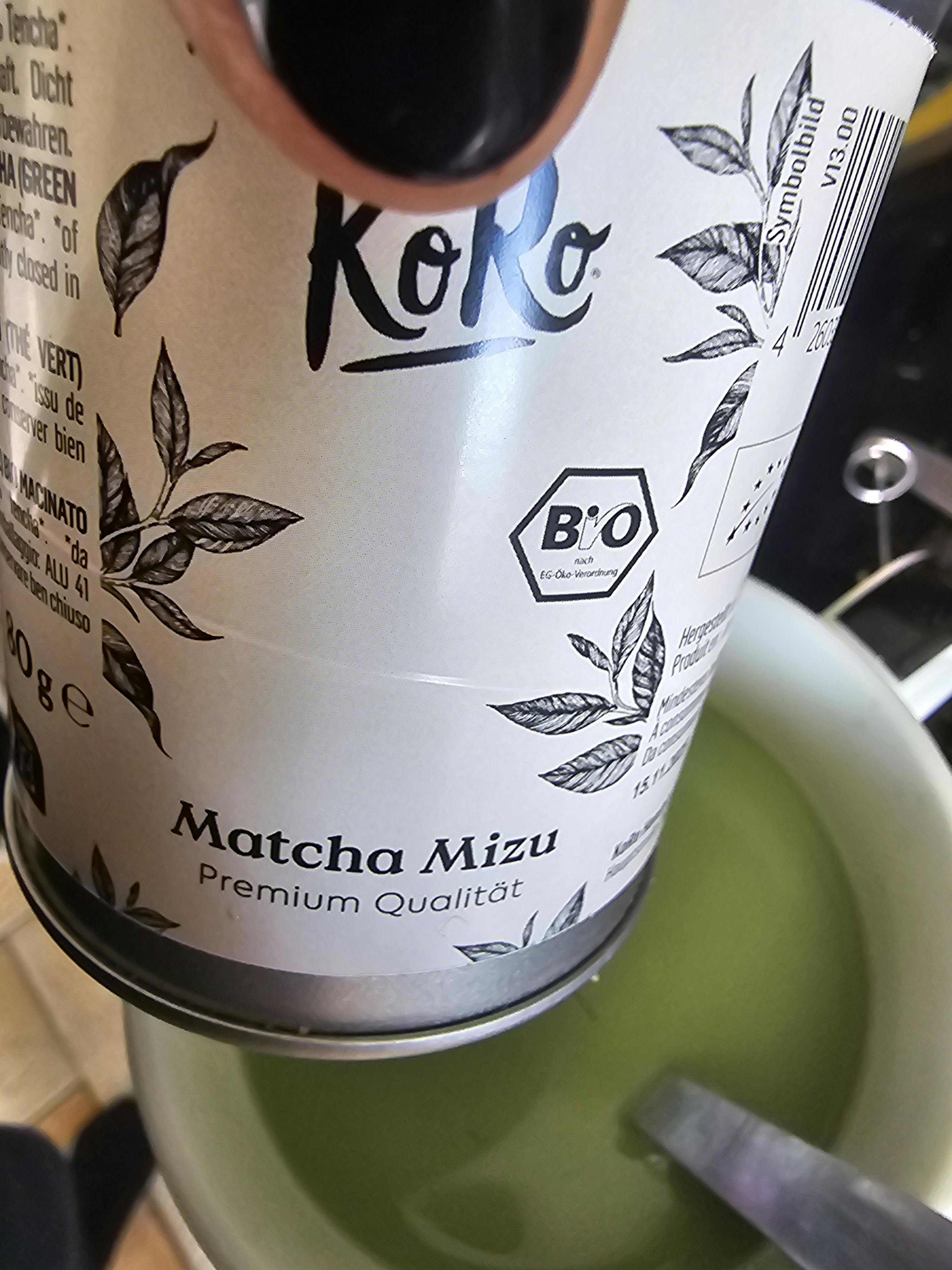a can of matcha mizu premium quality is being poured into a cup