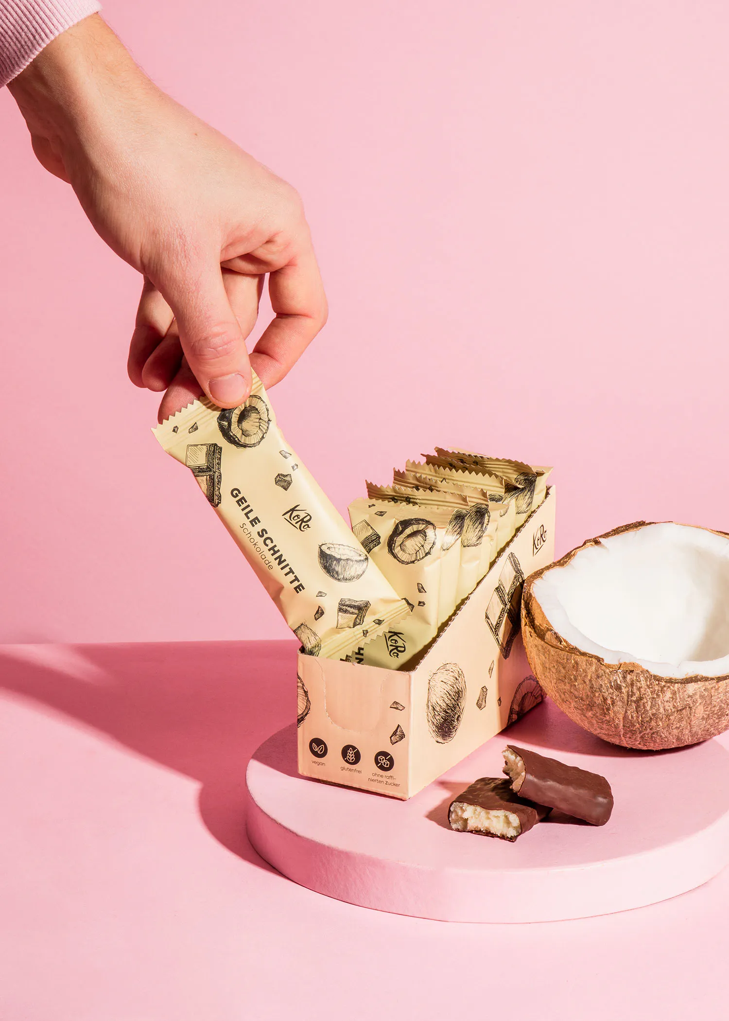 une personne prend une barre de chocolat de la boîte à côté d' une noix de coco