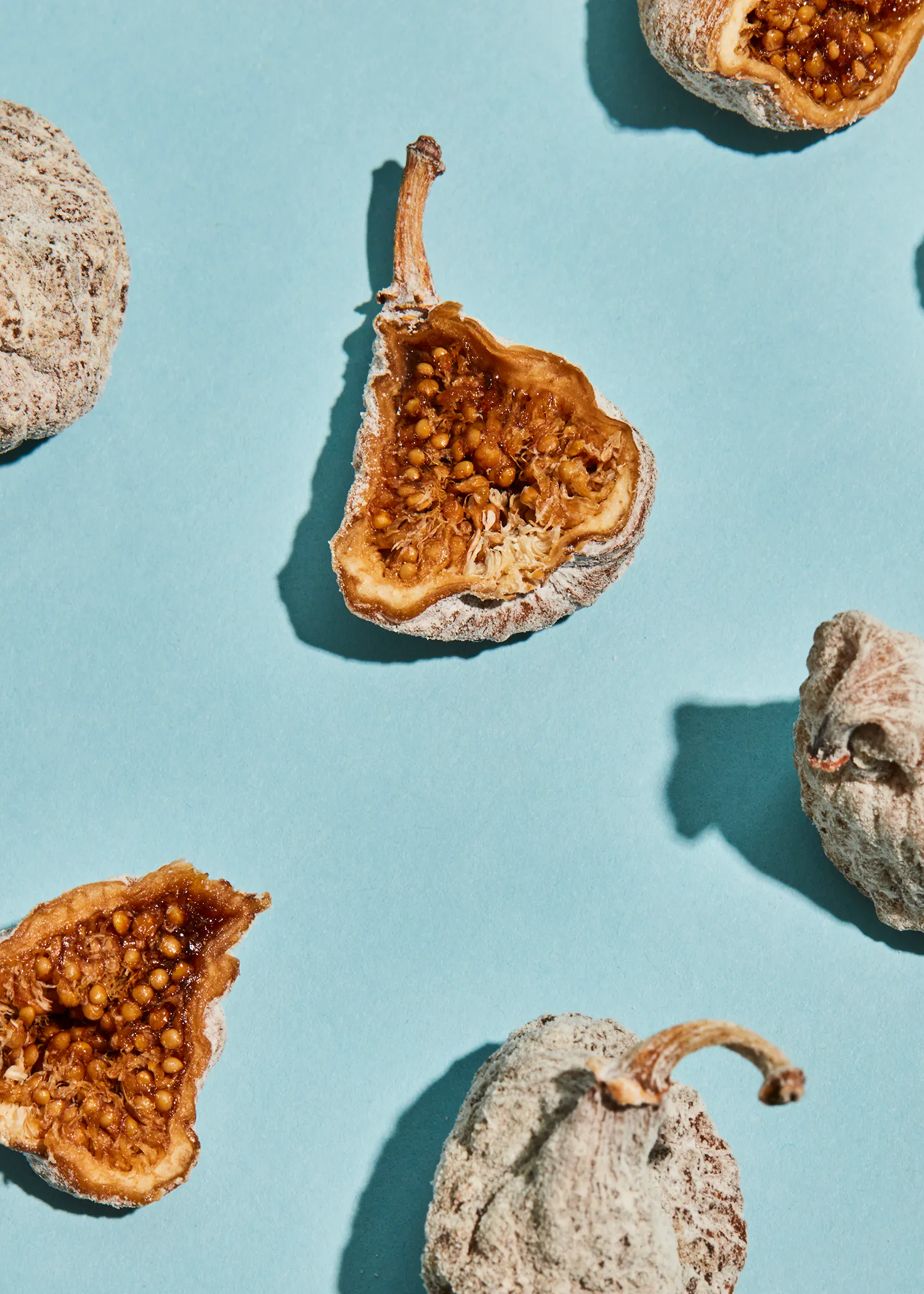 a bunch of dried figs on a blue background