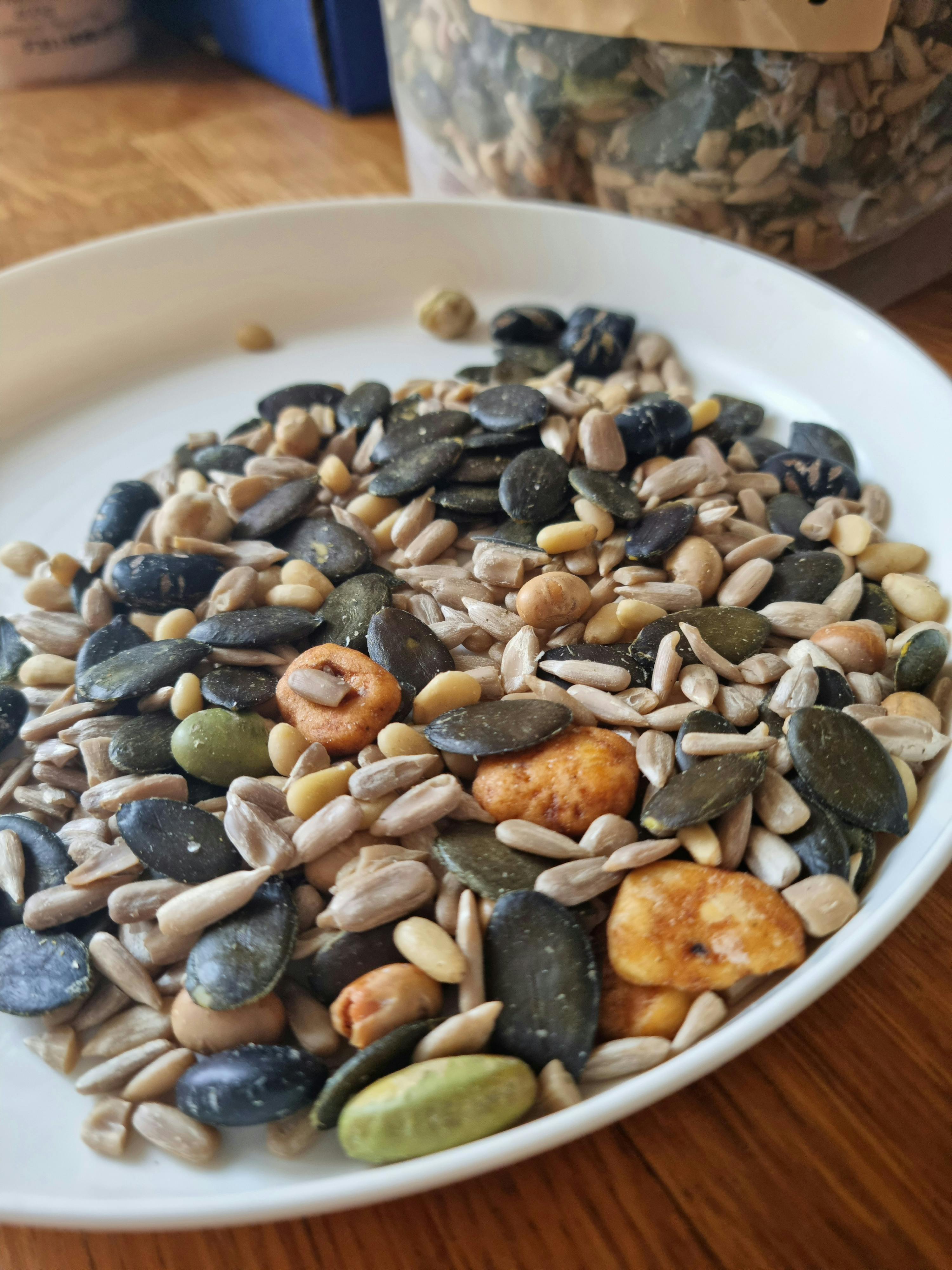 a white plate topped with a variety of seeds and nuts