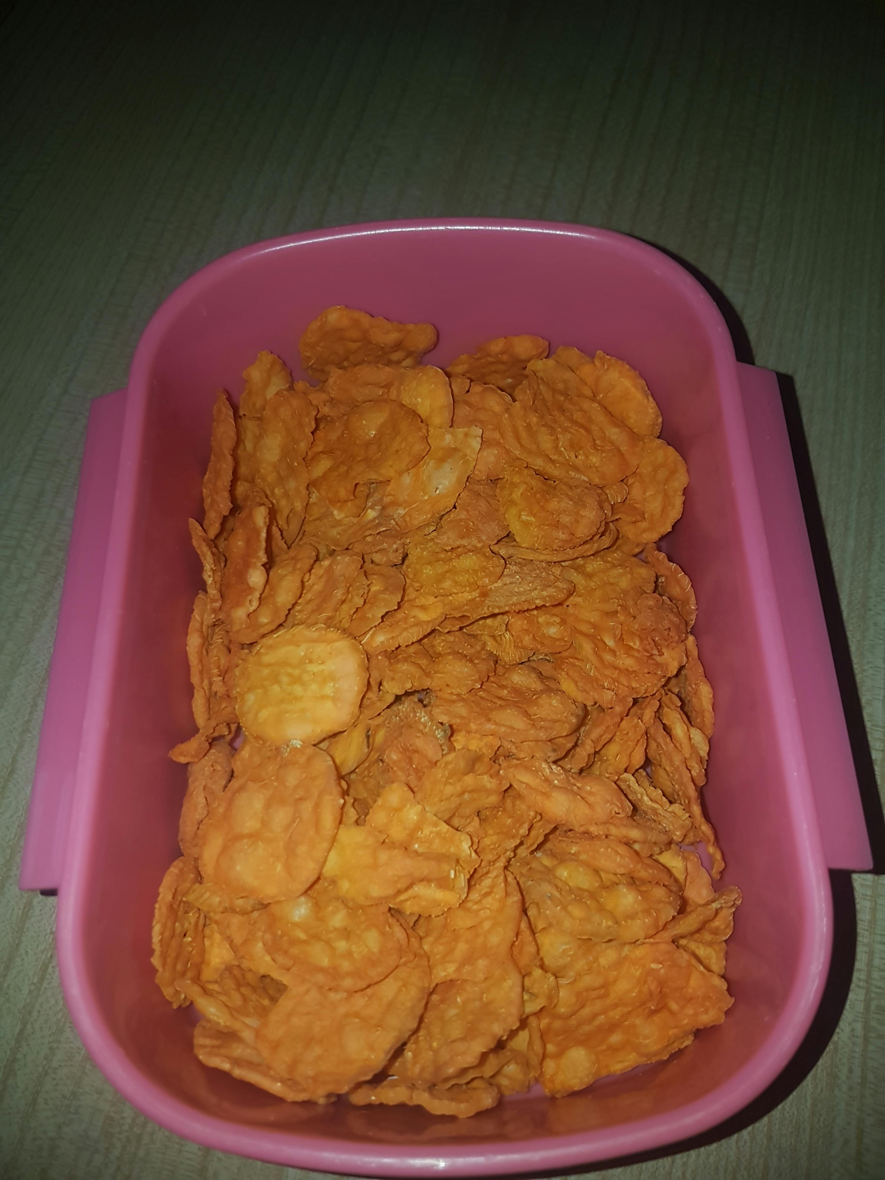 a pink plastic container filled with chips on a table