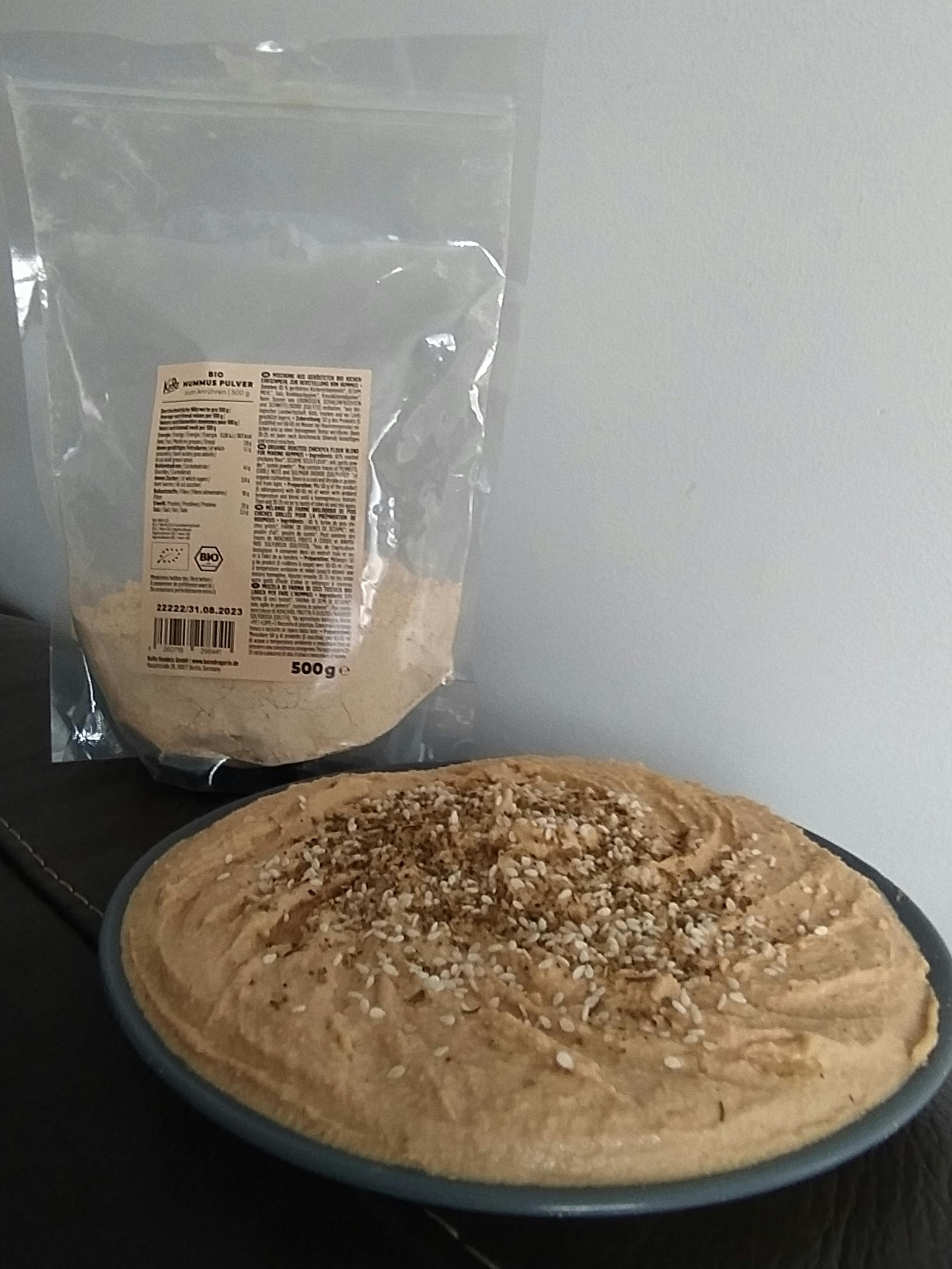 a bag of hummus next to a bowl of hummus