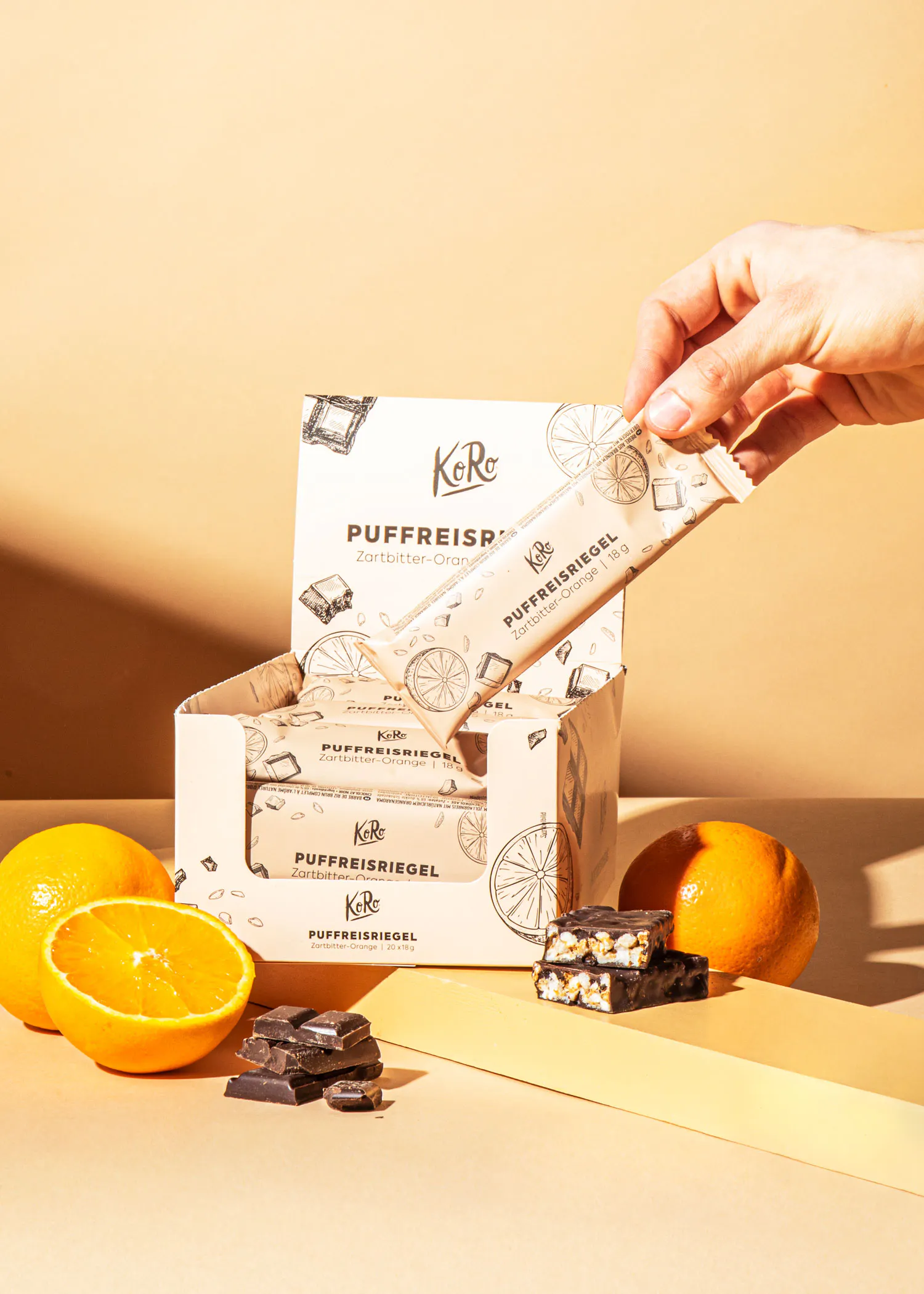 a person is holding a puffreisriegel bar in front of a box of puffreisriegel bars
