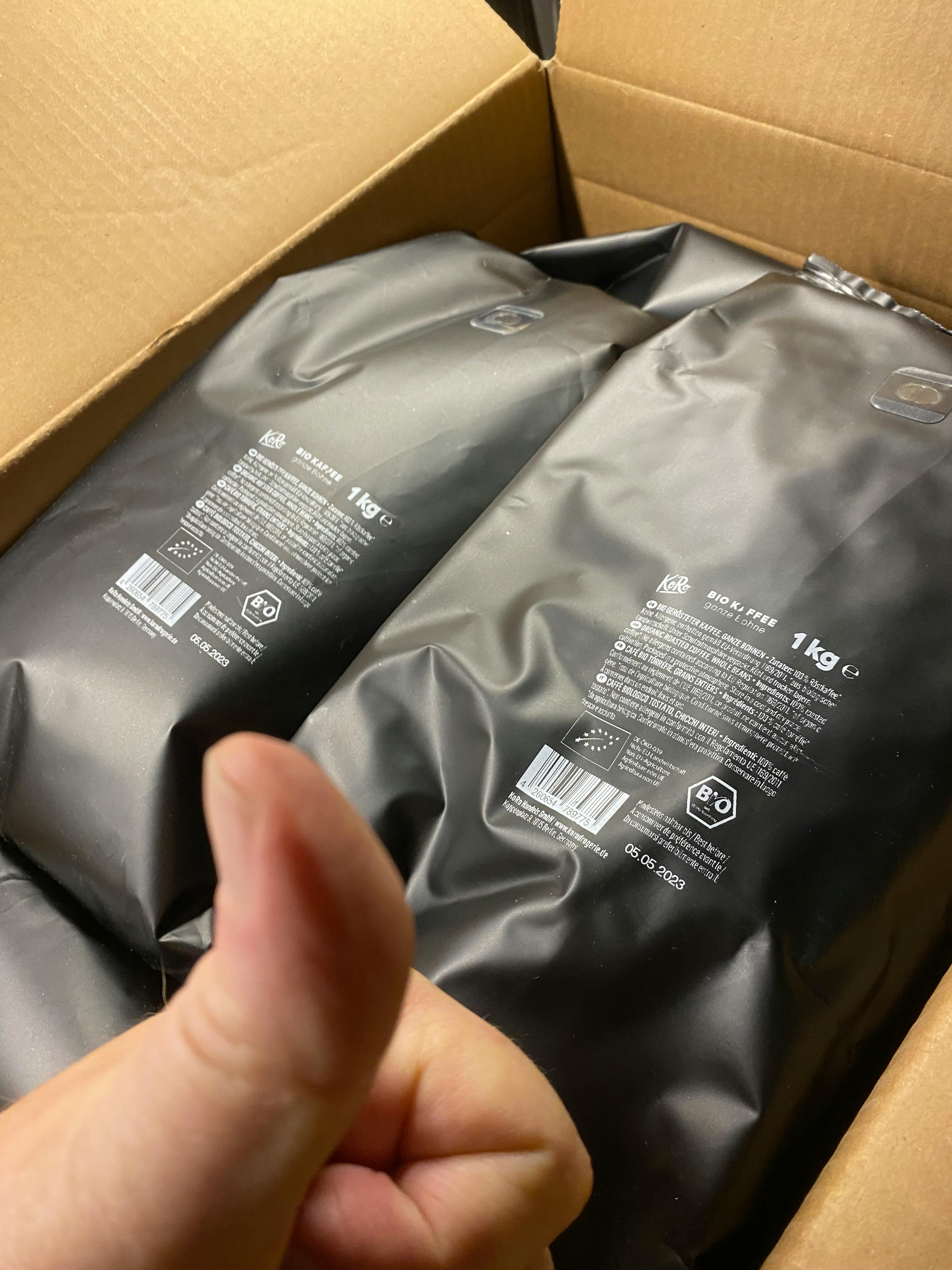 une personne tient deux sacs de 1kg dans une boîte en carton