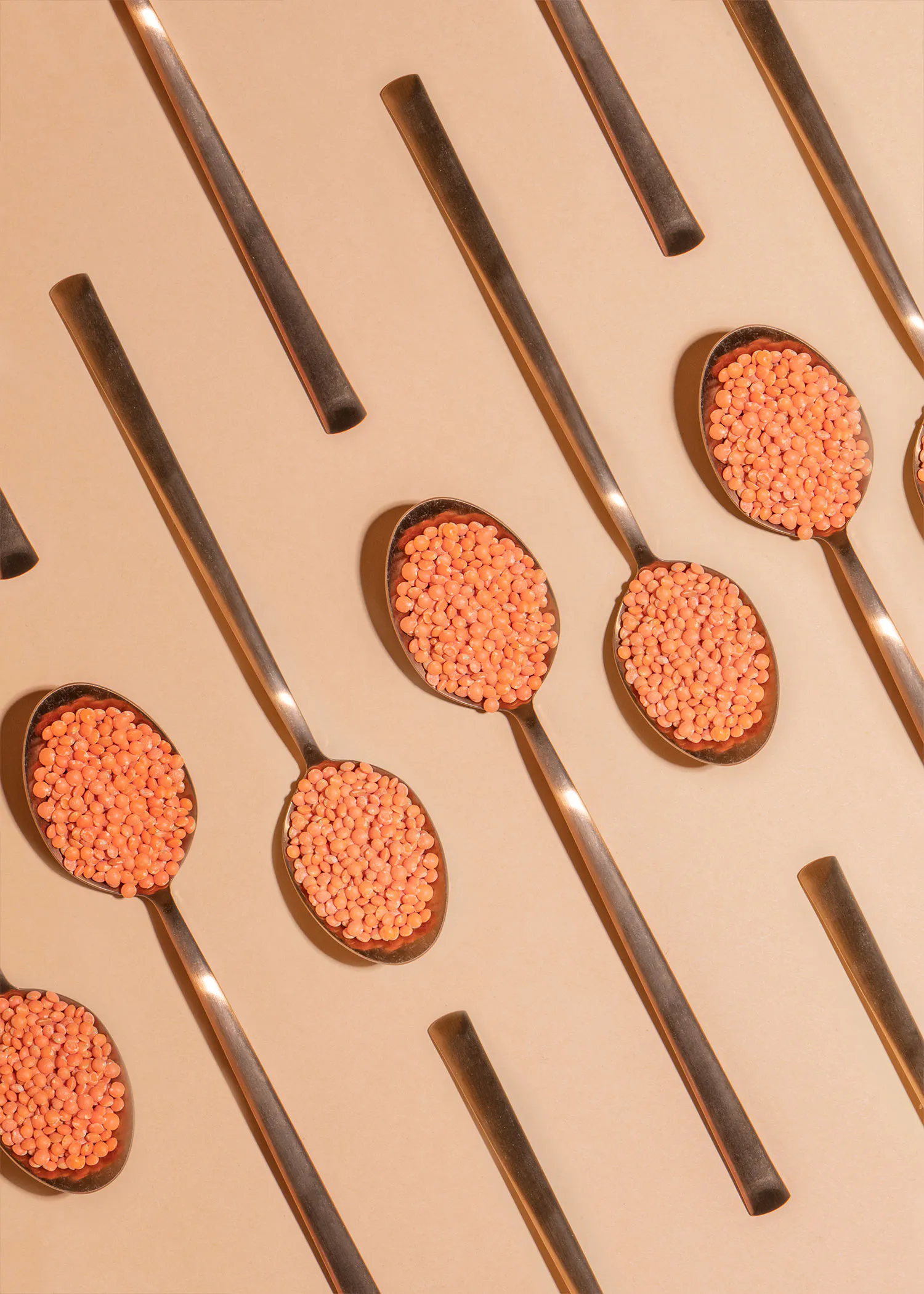 un groupe de cuillères remplies de lentilles rouges