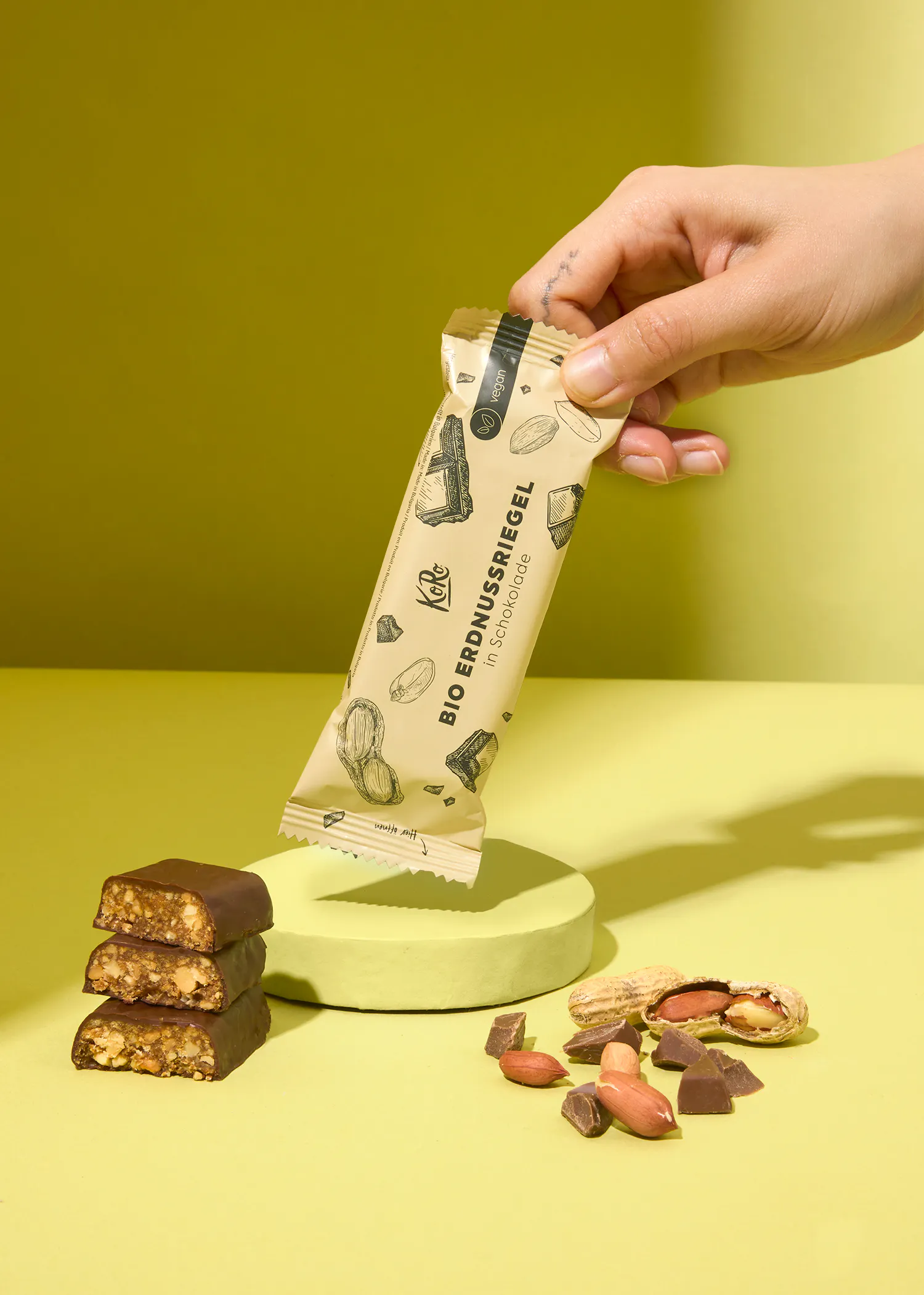 une personne tient une barre de chocolat bio erdnussriegel