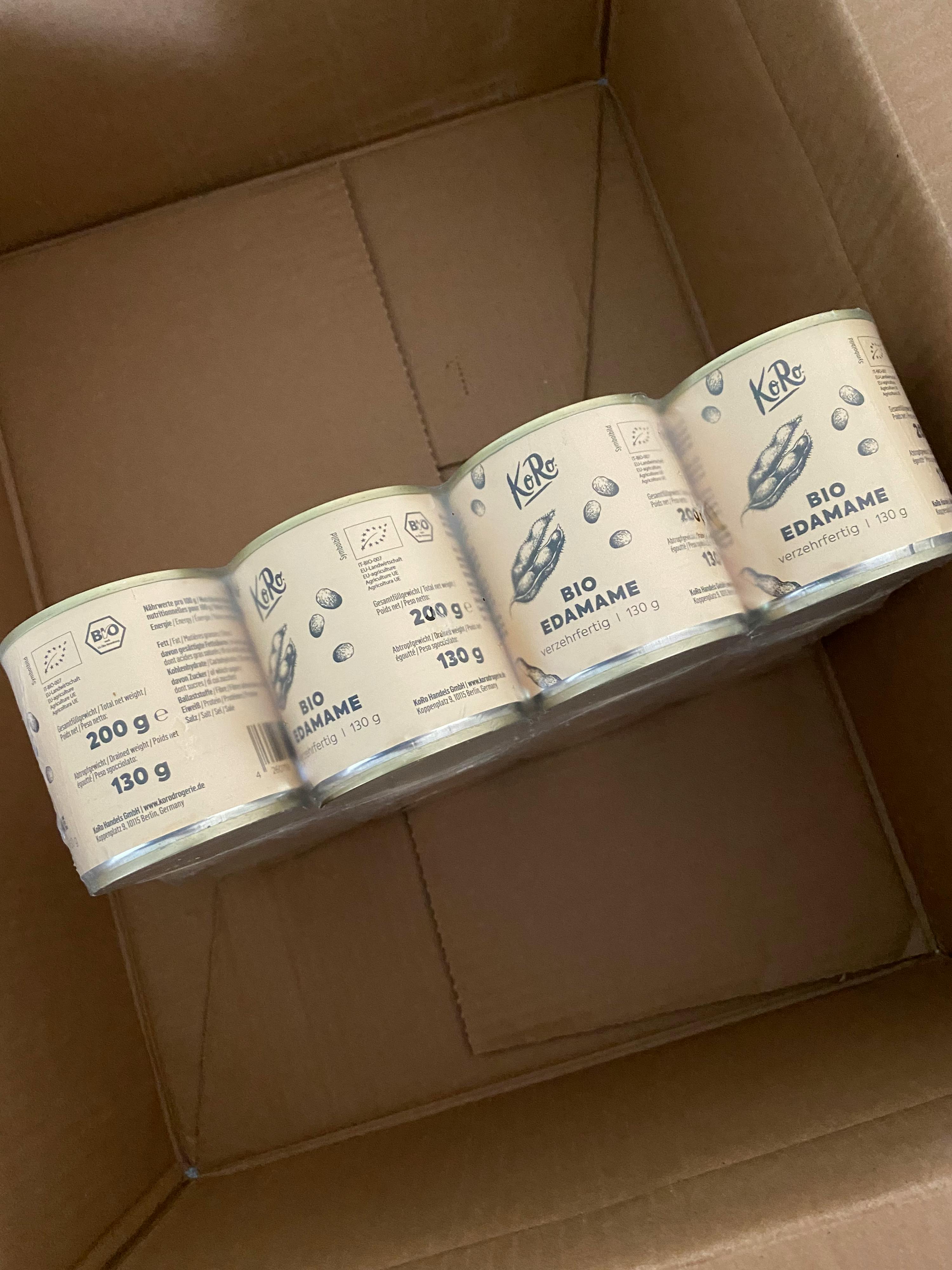 four cans of bio edamame in a cardboard box