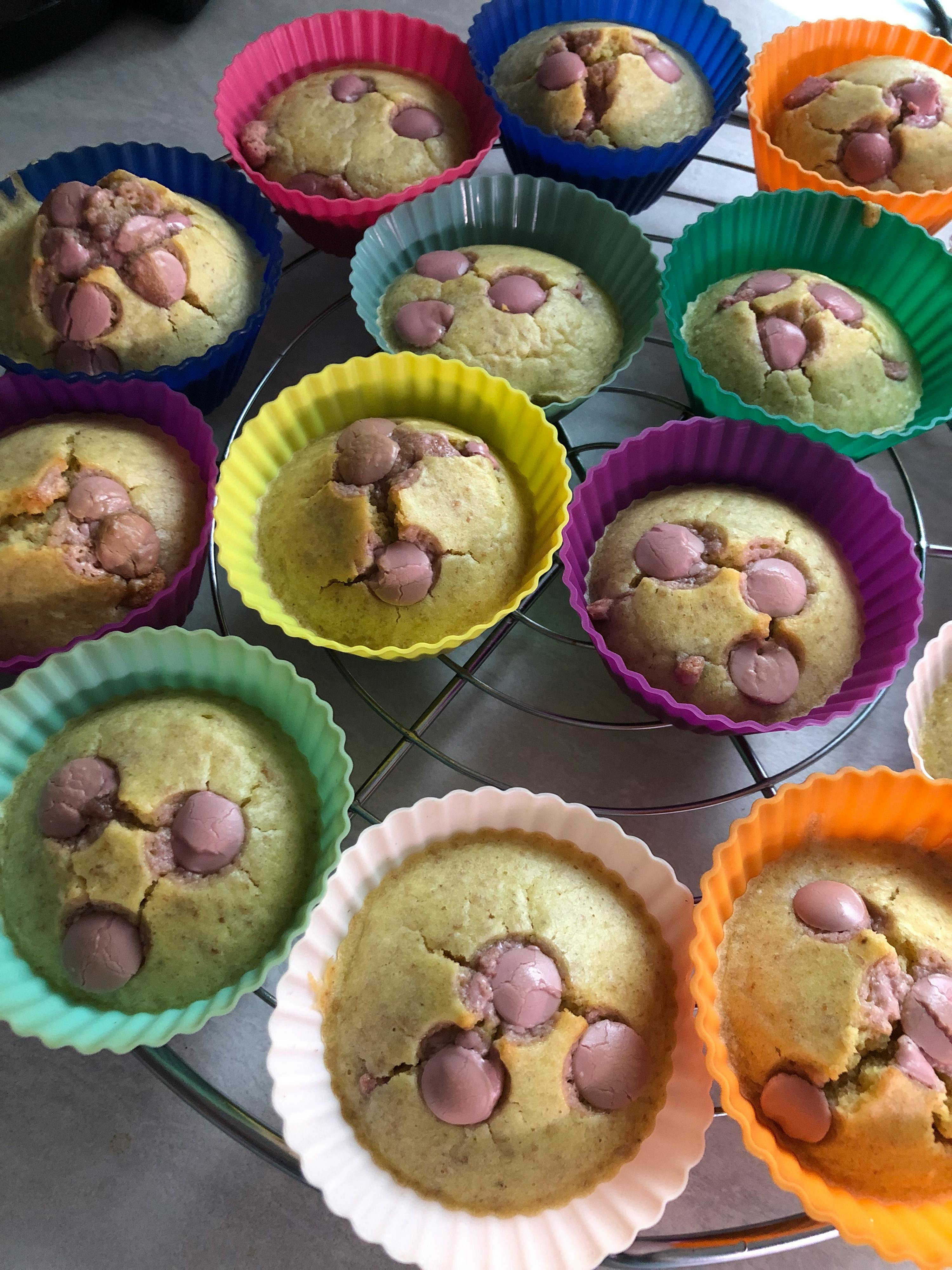 eine Reihe von bunten Muffins mit Schokoladenstückchen darauf