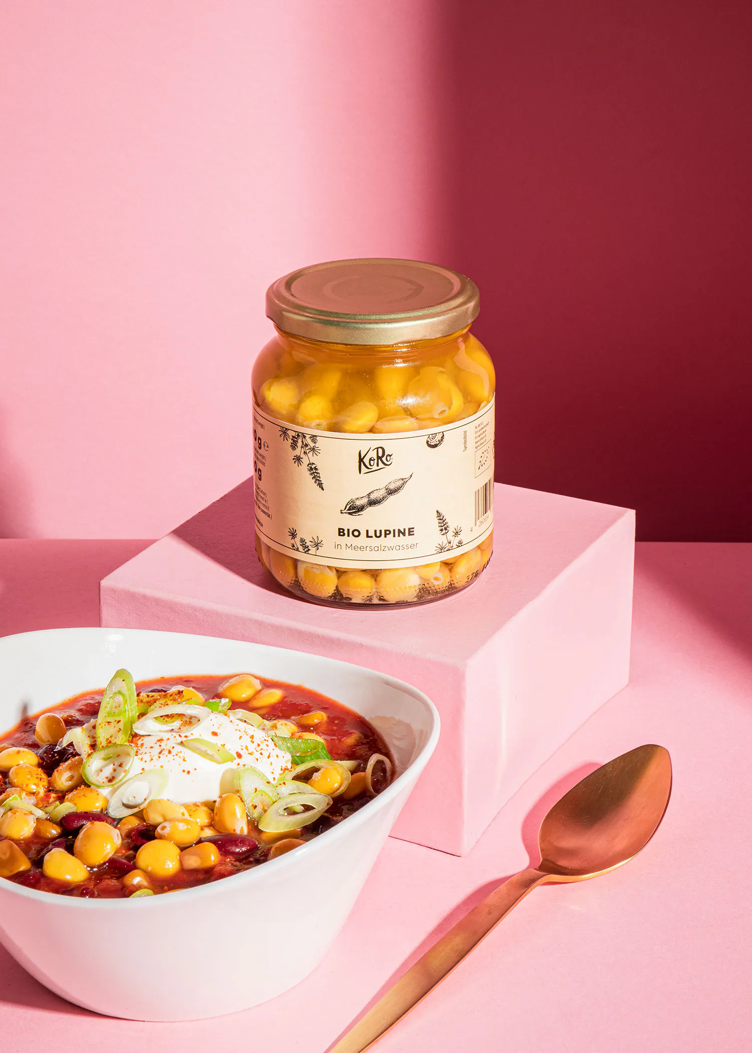 un bol de soupe est assis à côté d' un bocal de haricots bio lupine