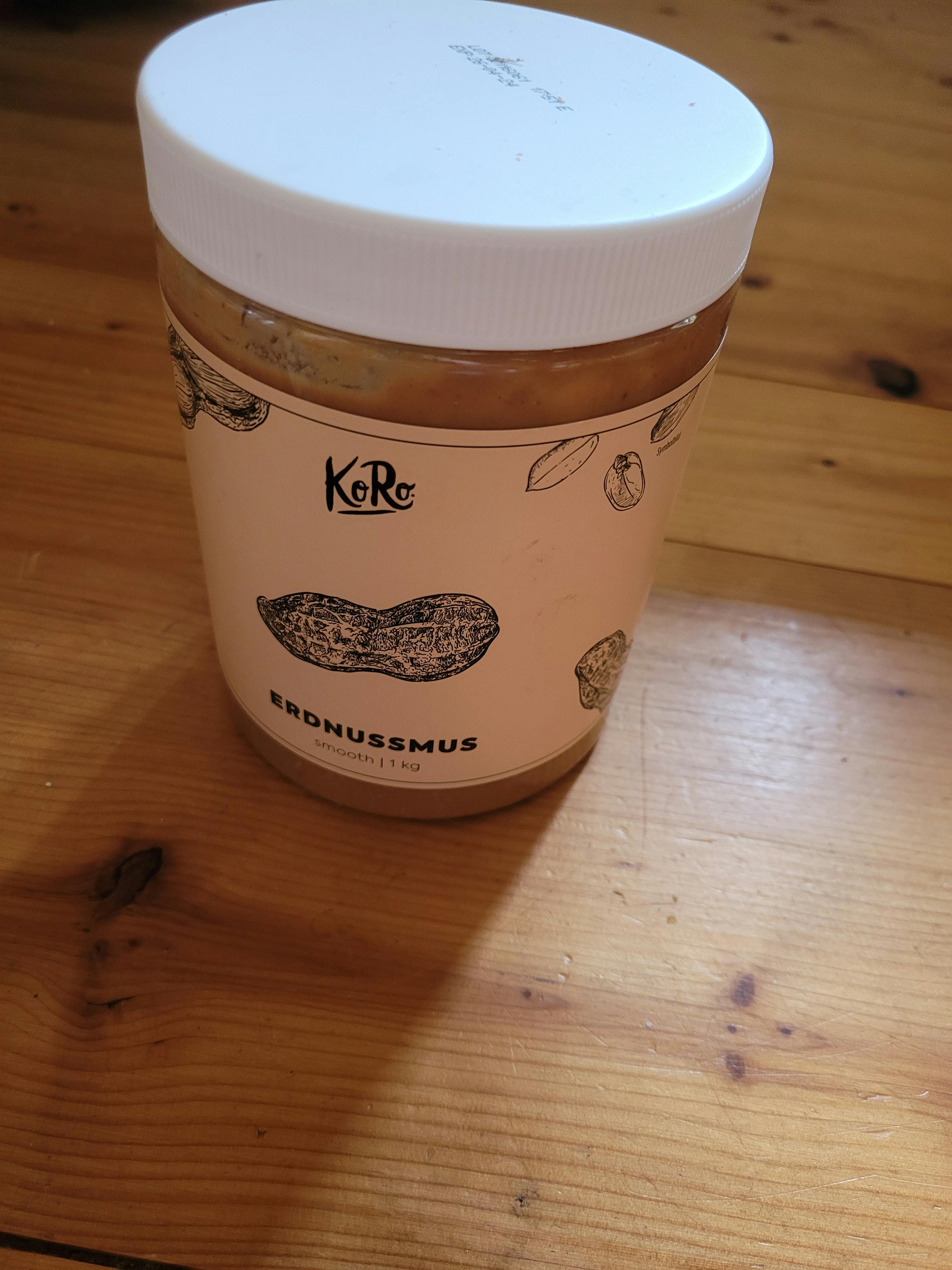 un barattolo di burro di arachidi koko è seduto su un tavolo di legno