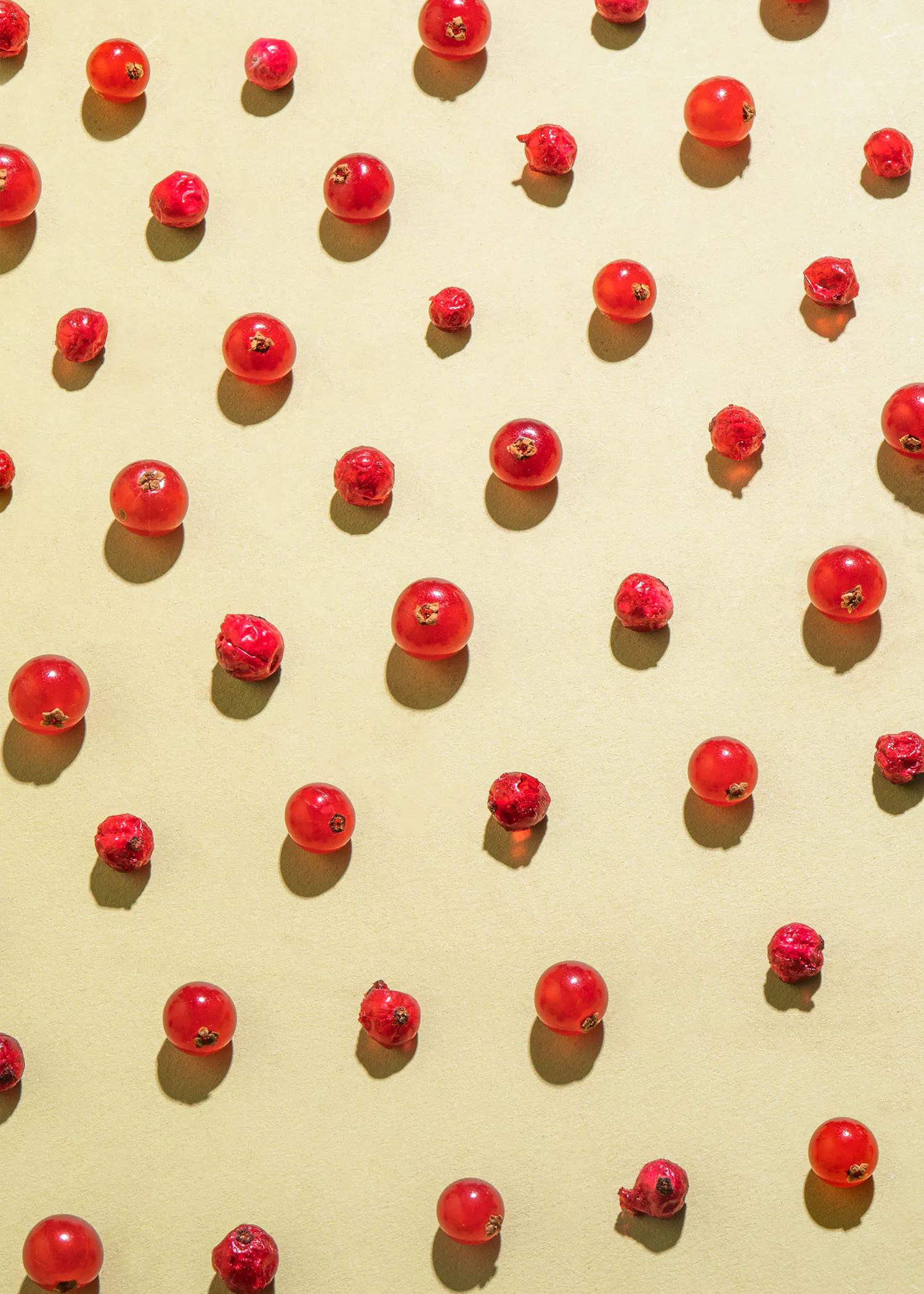 a pattern of red berries on a yellow surface