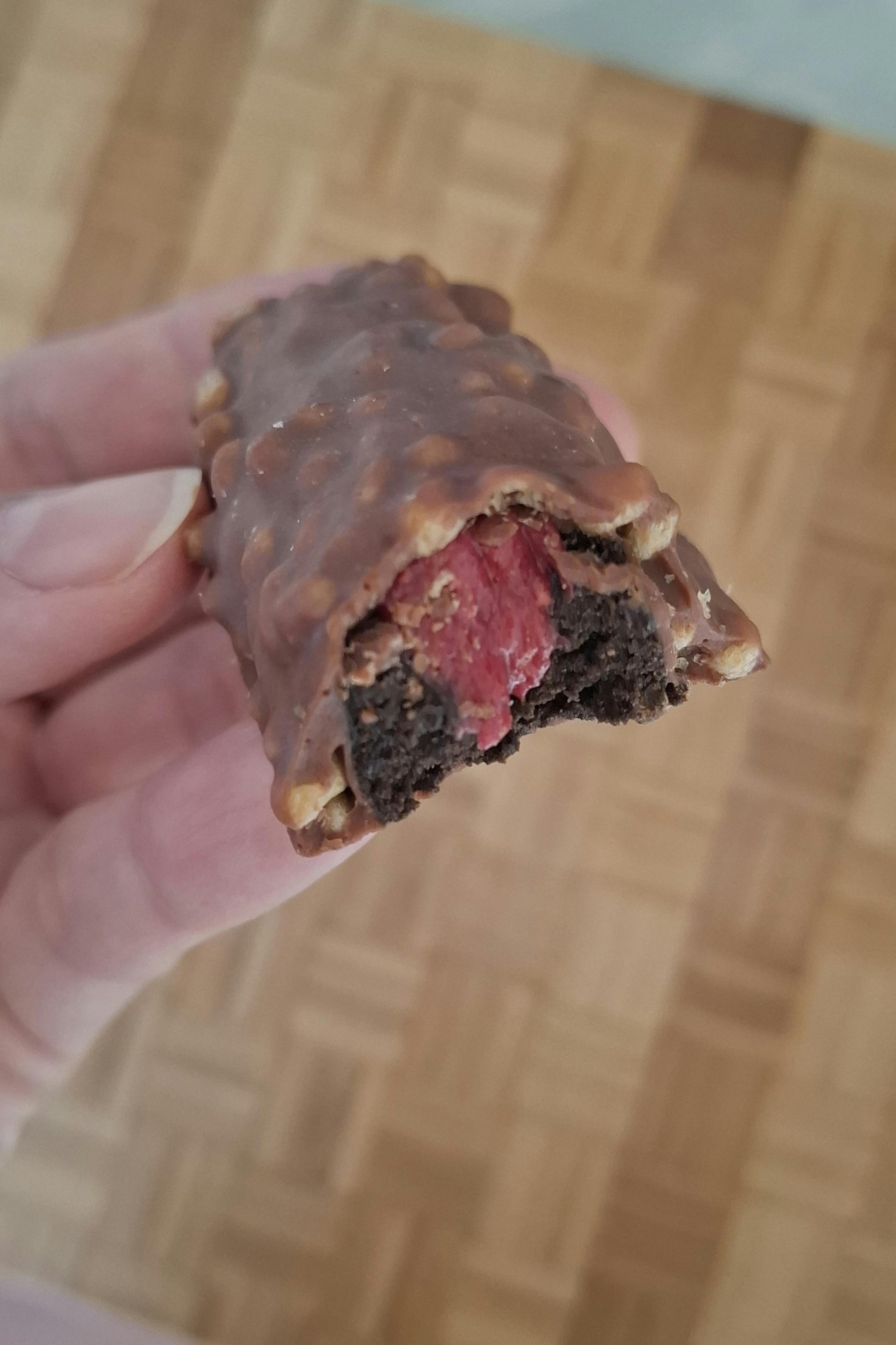 eine Person hält einen Schokoladenkuchen mit einem Stück herausgenommen