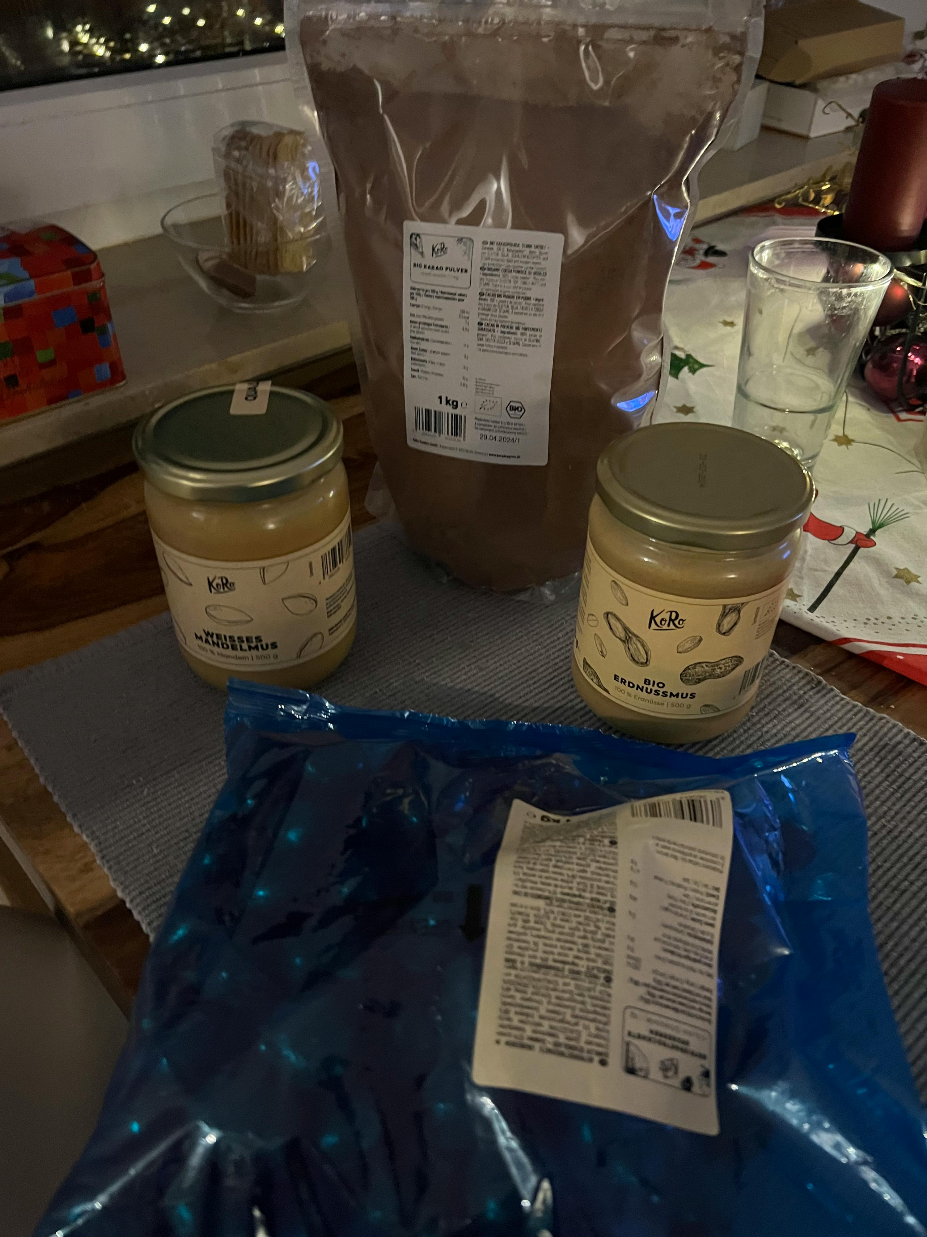 deux bocaux de beurre d' arachide sont posés sur une table avec d' autres produits