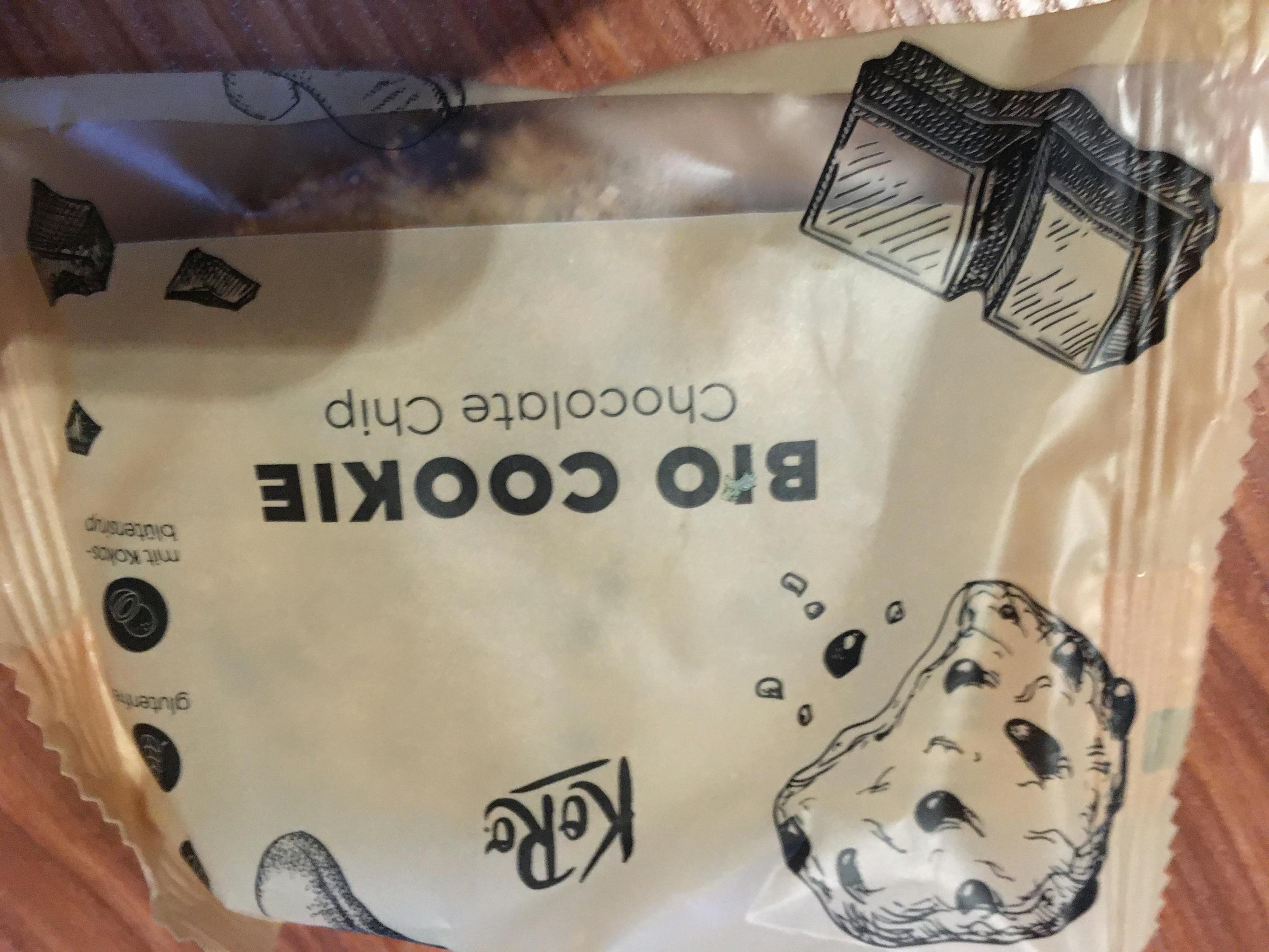 ein Bio-Keks mit Schokoladenchips liegt auf einem Holztisch