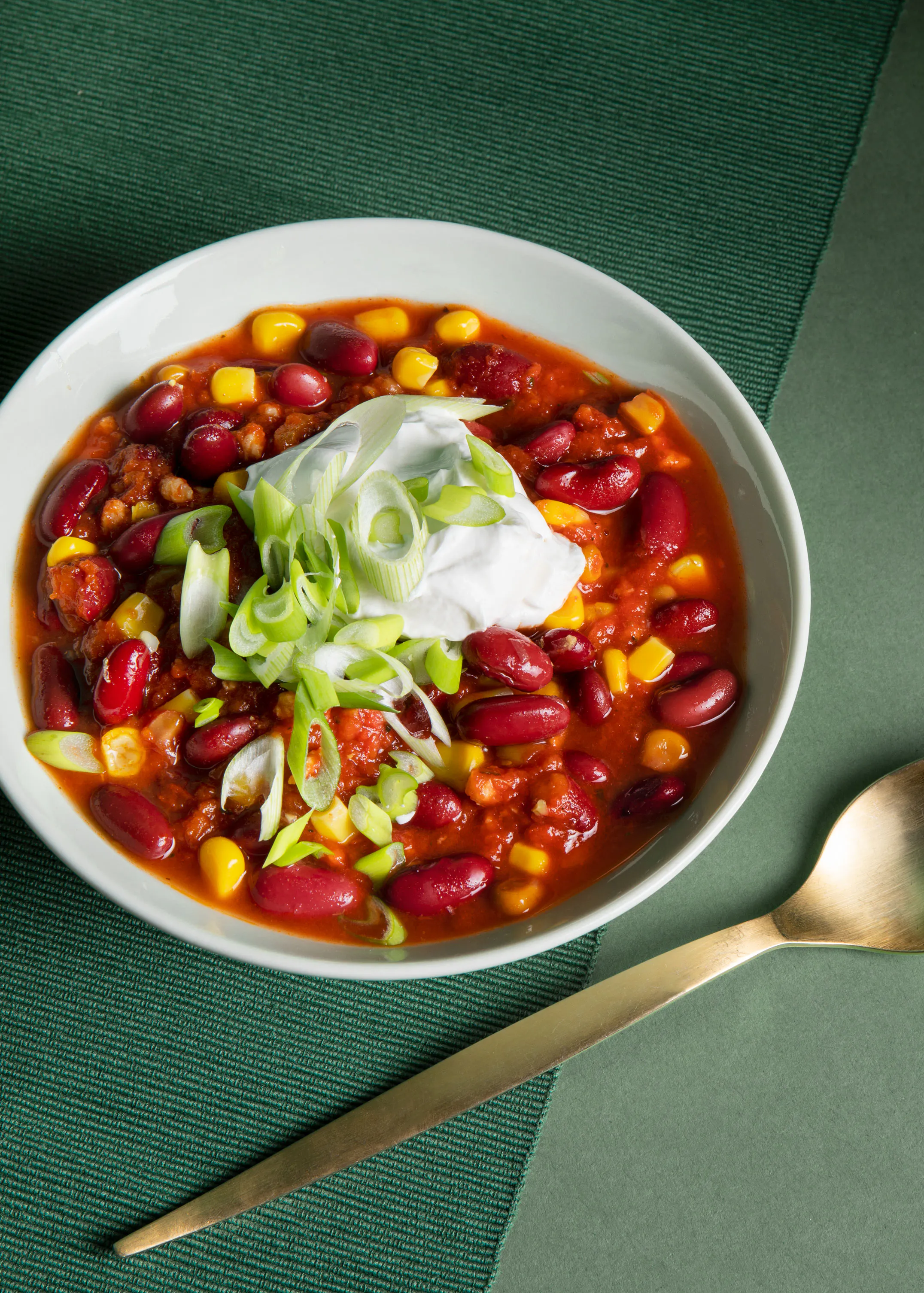 un bol de chili avec des haricots , du maïs et de la crème sure