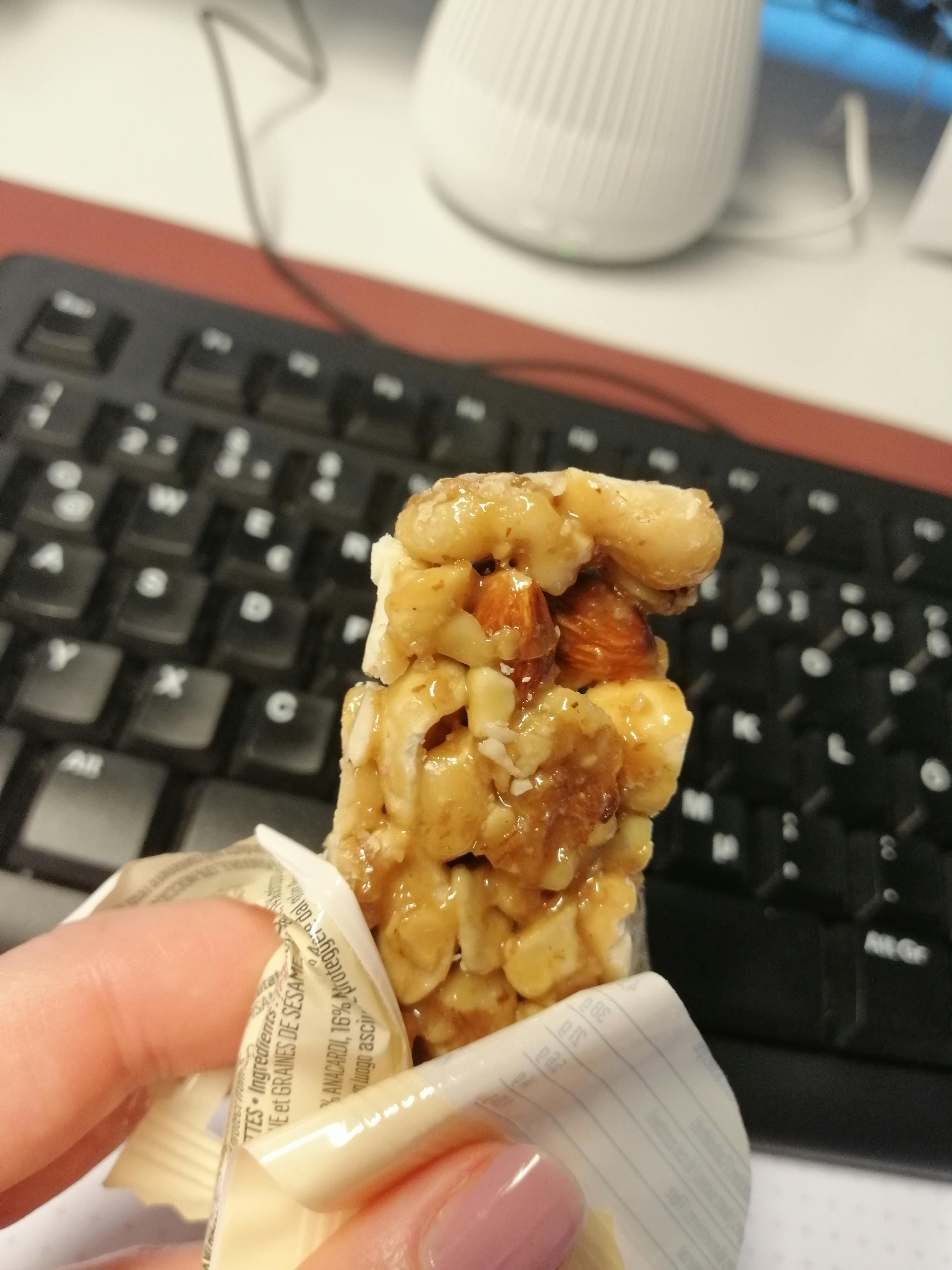 a person is holding a snack bar in front of a keyboard