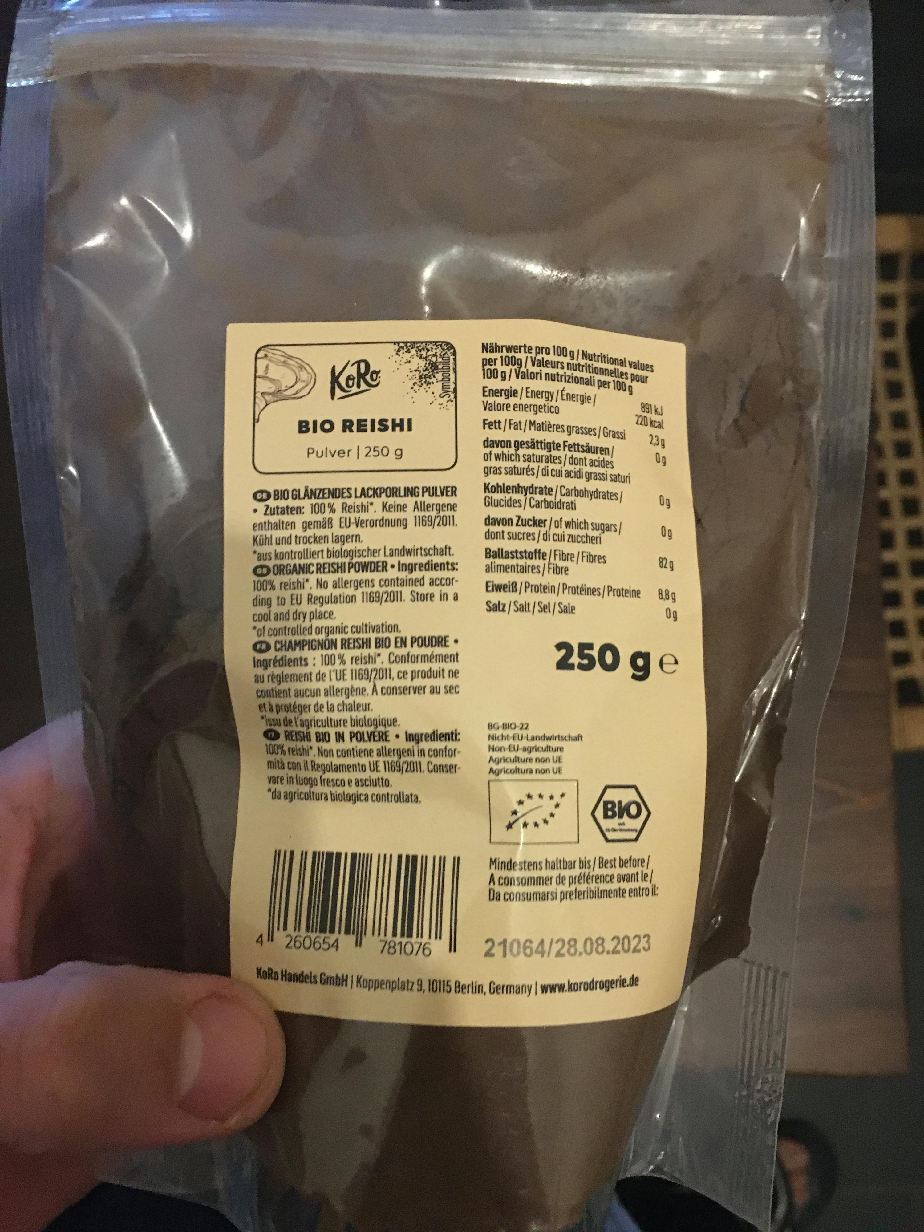 eine Person hält einen Plastikbeutel mit 250 g Kaffeepulver in der Hand