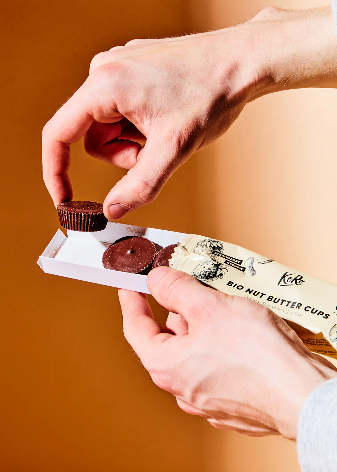 une personne tient une boîte de tasses de beurre de noix bio