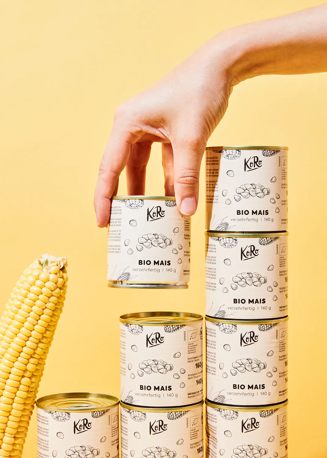 a hand is holding up a can of bio mais