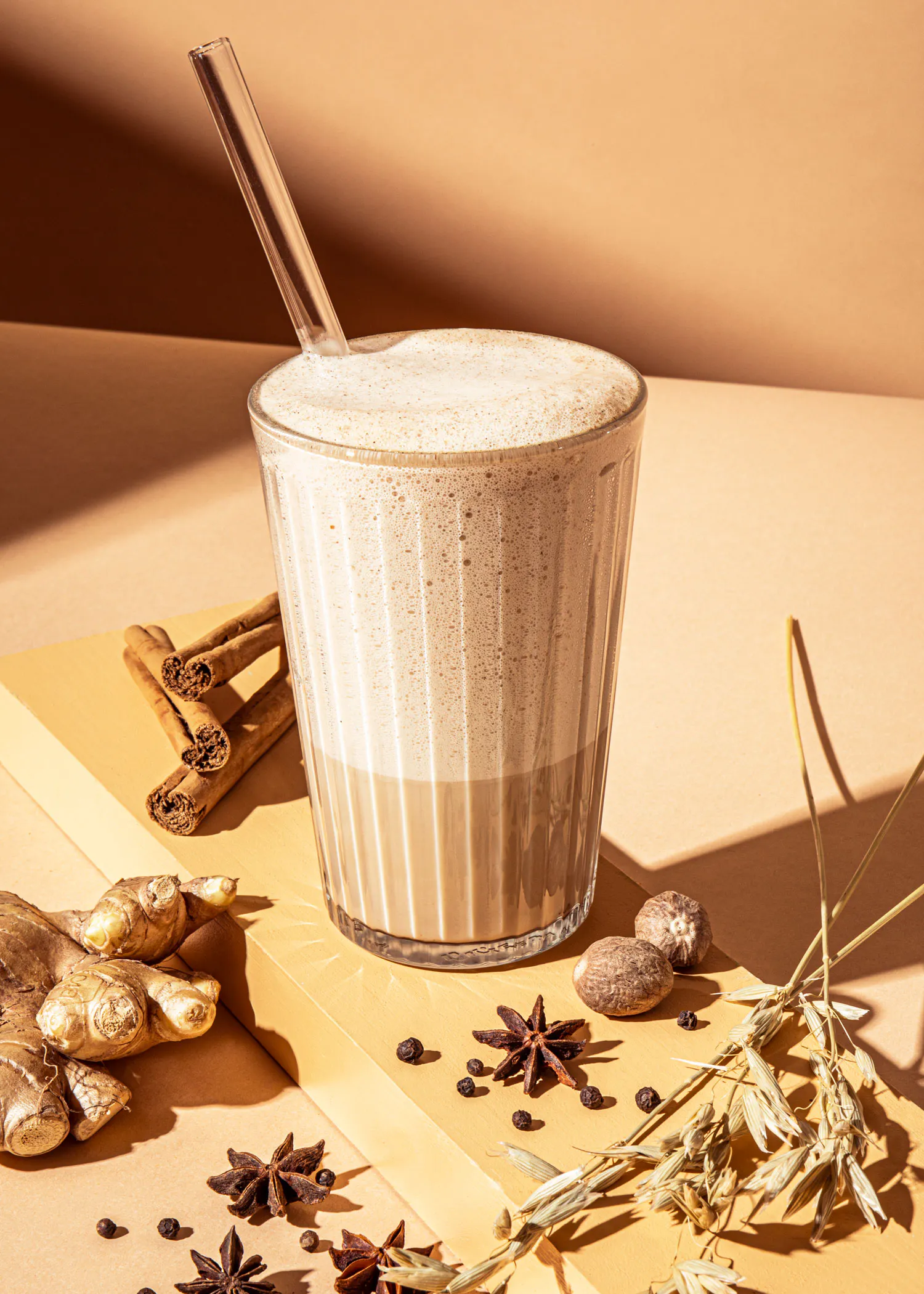 un milkshake avec une paille est assis sur une table avec des épices
