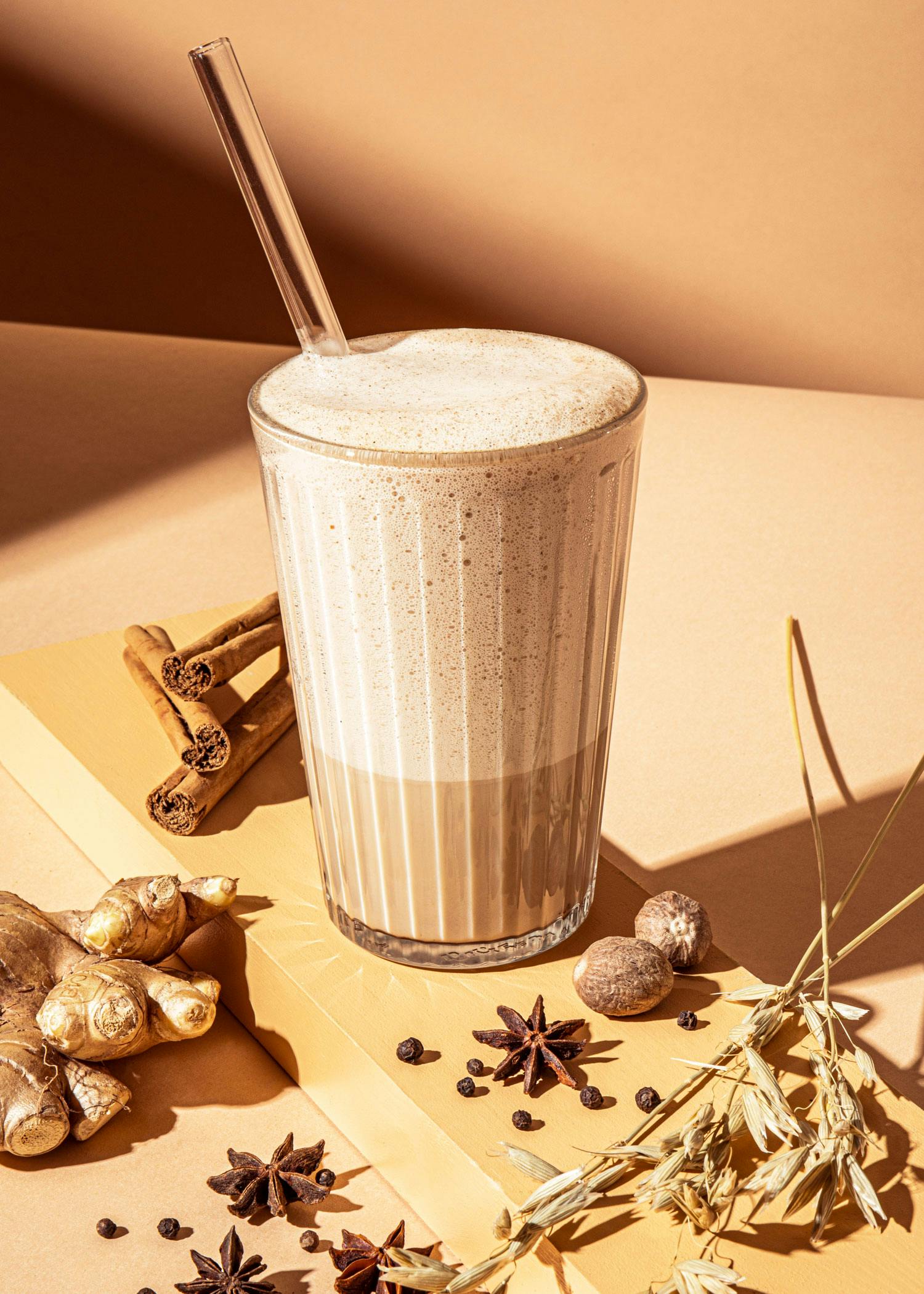 un milkshake avec une paille est assis sur une table avec des épices