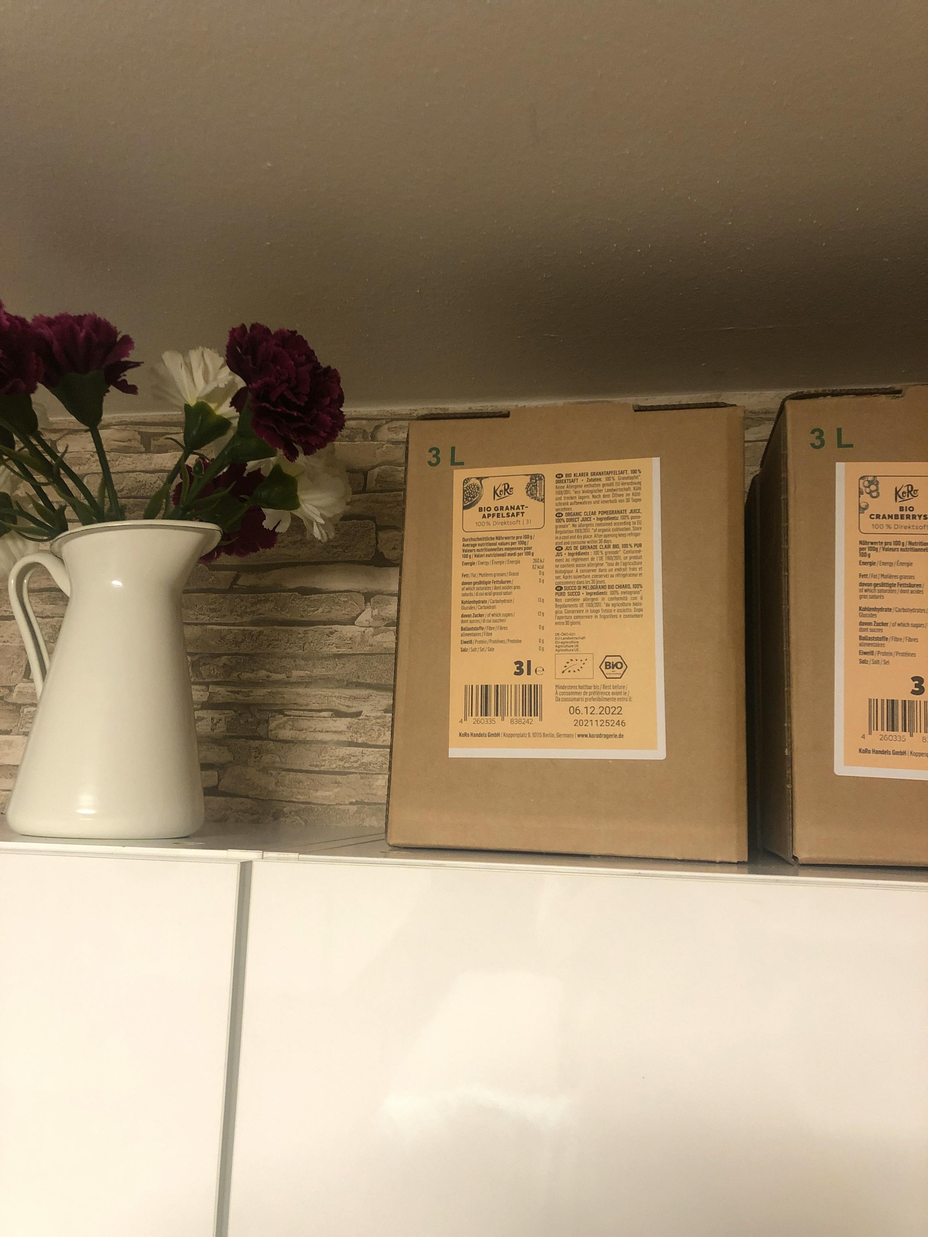 due scatole di cartone con l' etichetta " 3l " sono su un tavolo accanto a un vaso di fiori