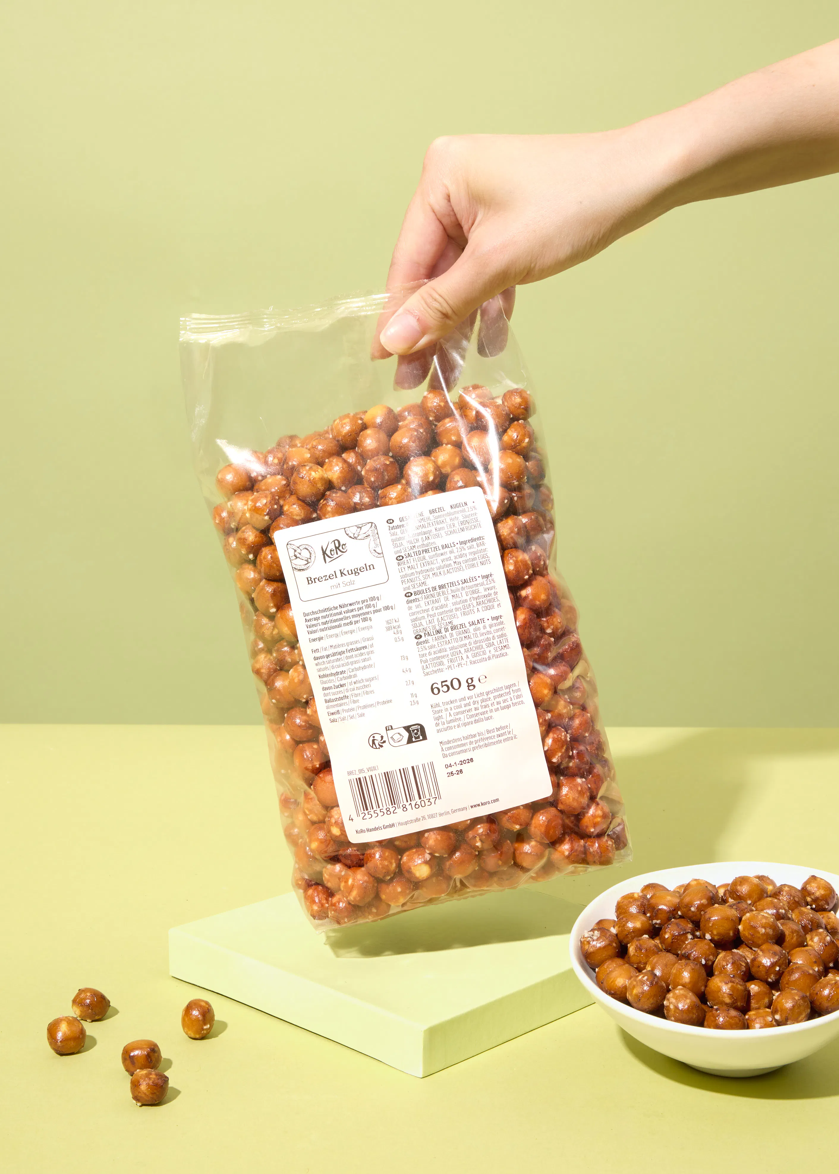 a hand is holding a bag of roasted nuggets