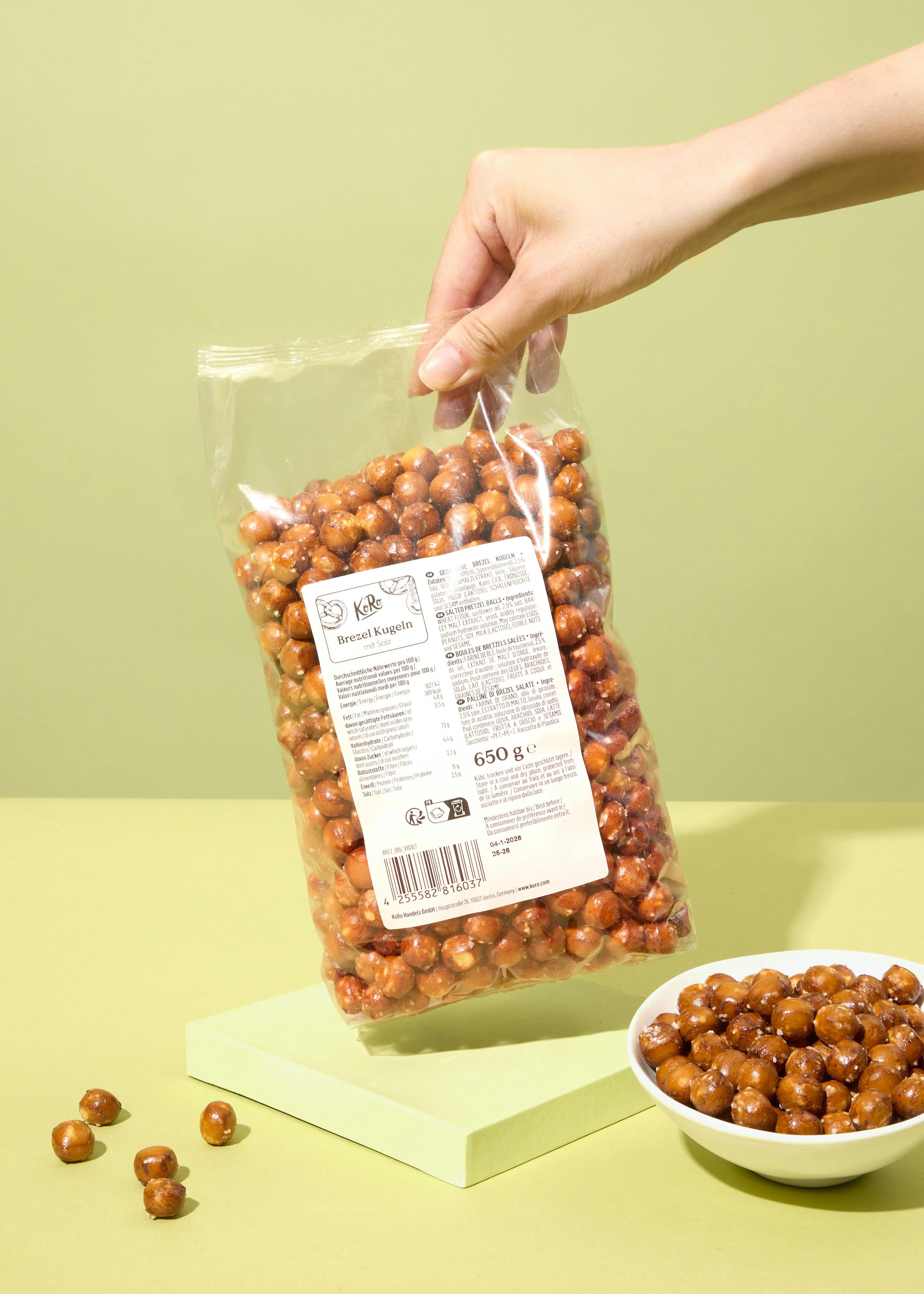 eine Person hält eine Tüte gerösteten Erdnüsse in der Hand