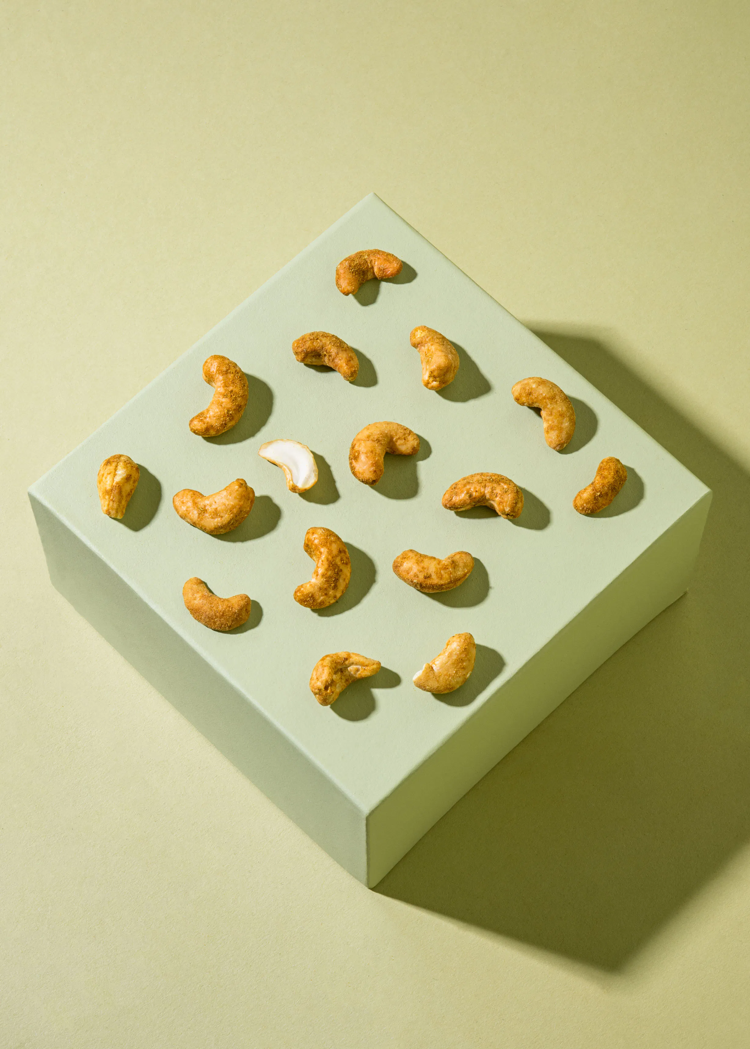 des noix de cajou sont disposées sur une surface verte