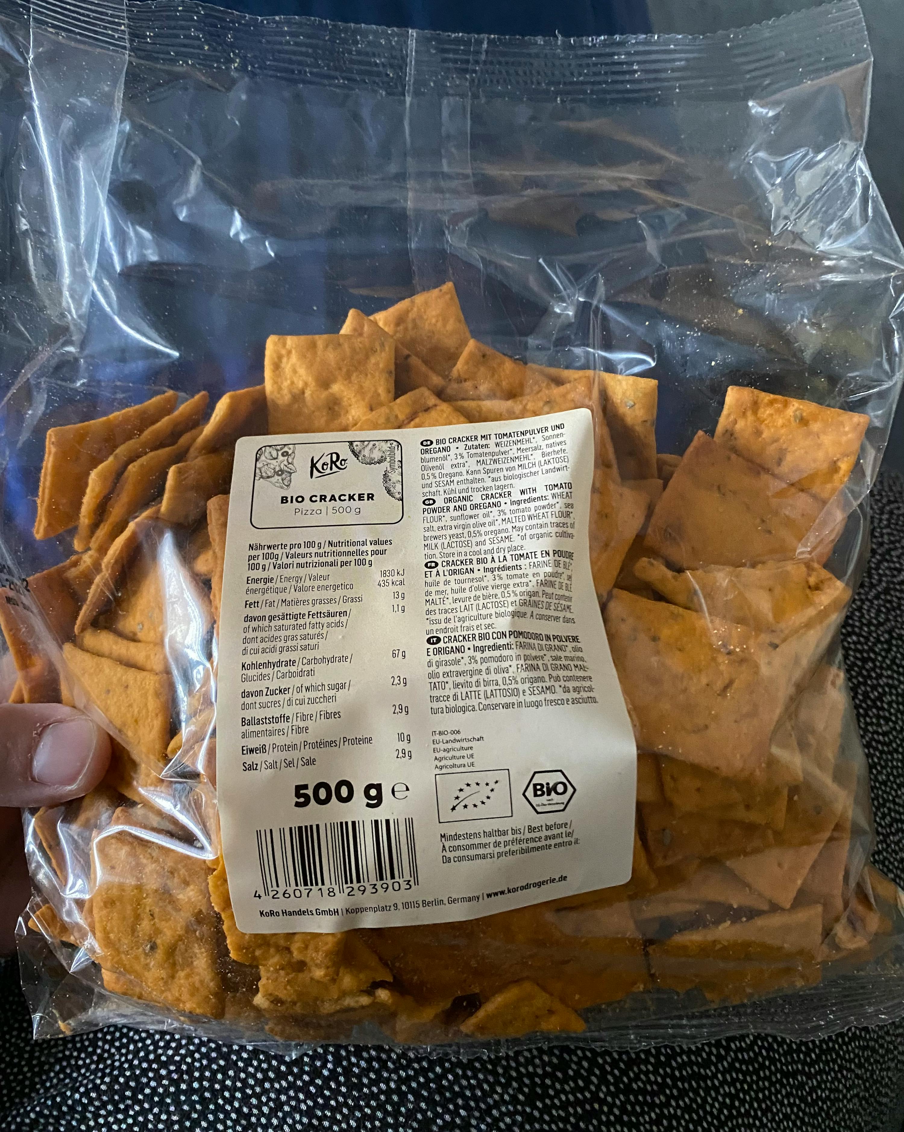 una persona tiene in mano un sacchetto di cracker bio 500 g
