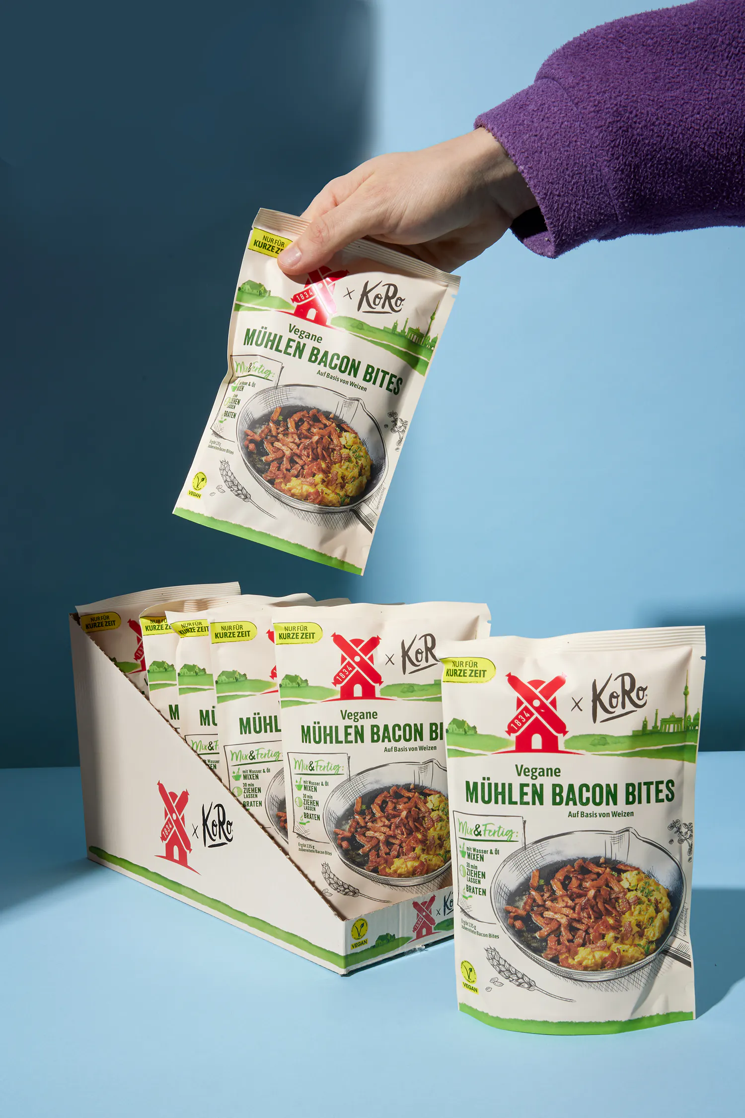 eine Person hält eine Tüte veganer Mühlen Bacon-Bites in der Hand
