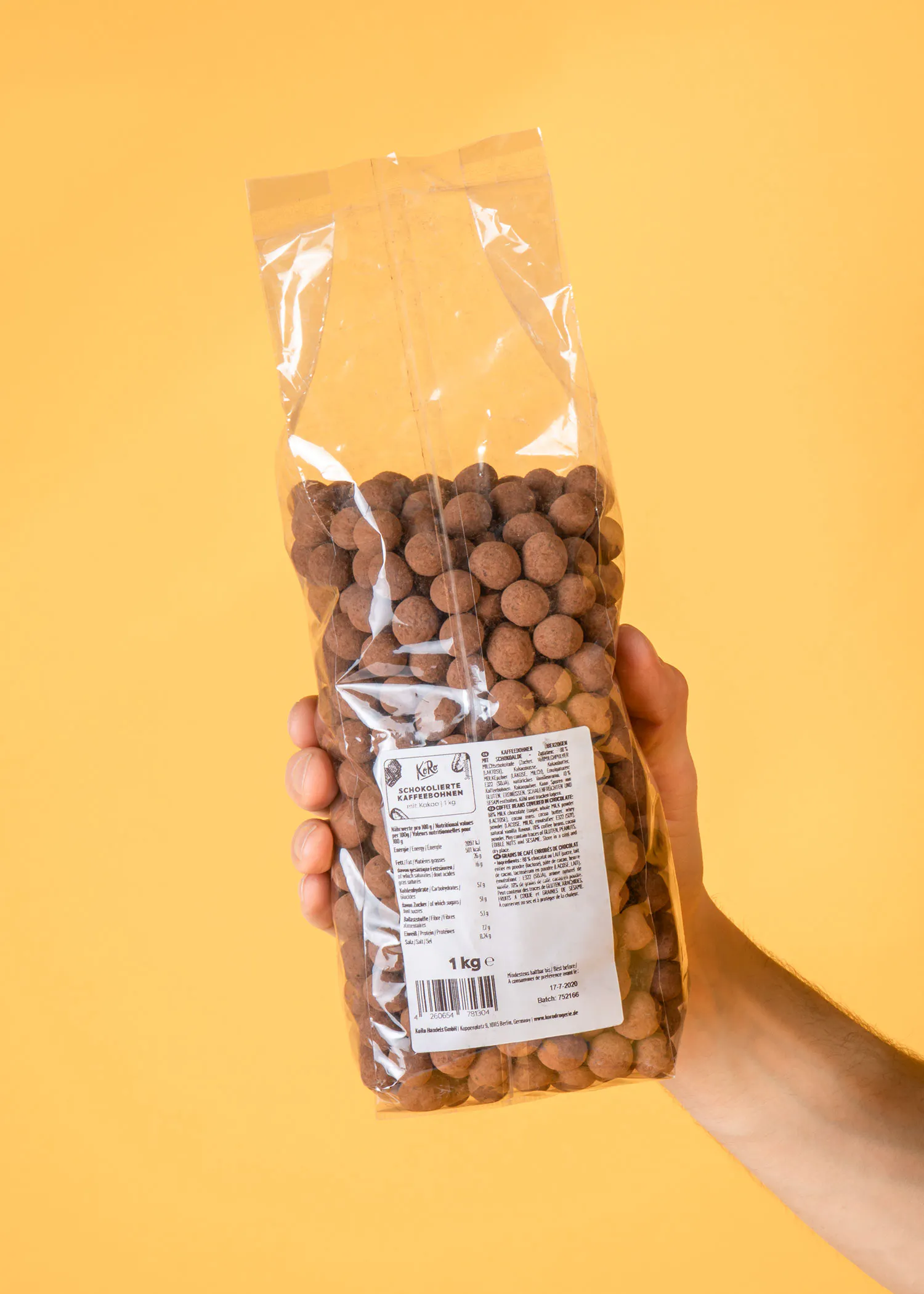 une personne tient un sac d' amandes au chocolat