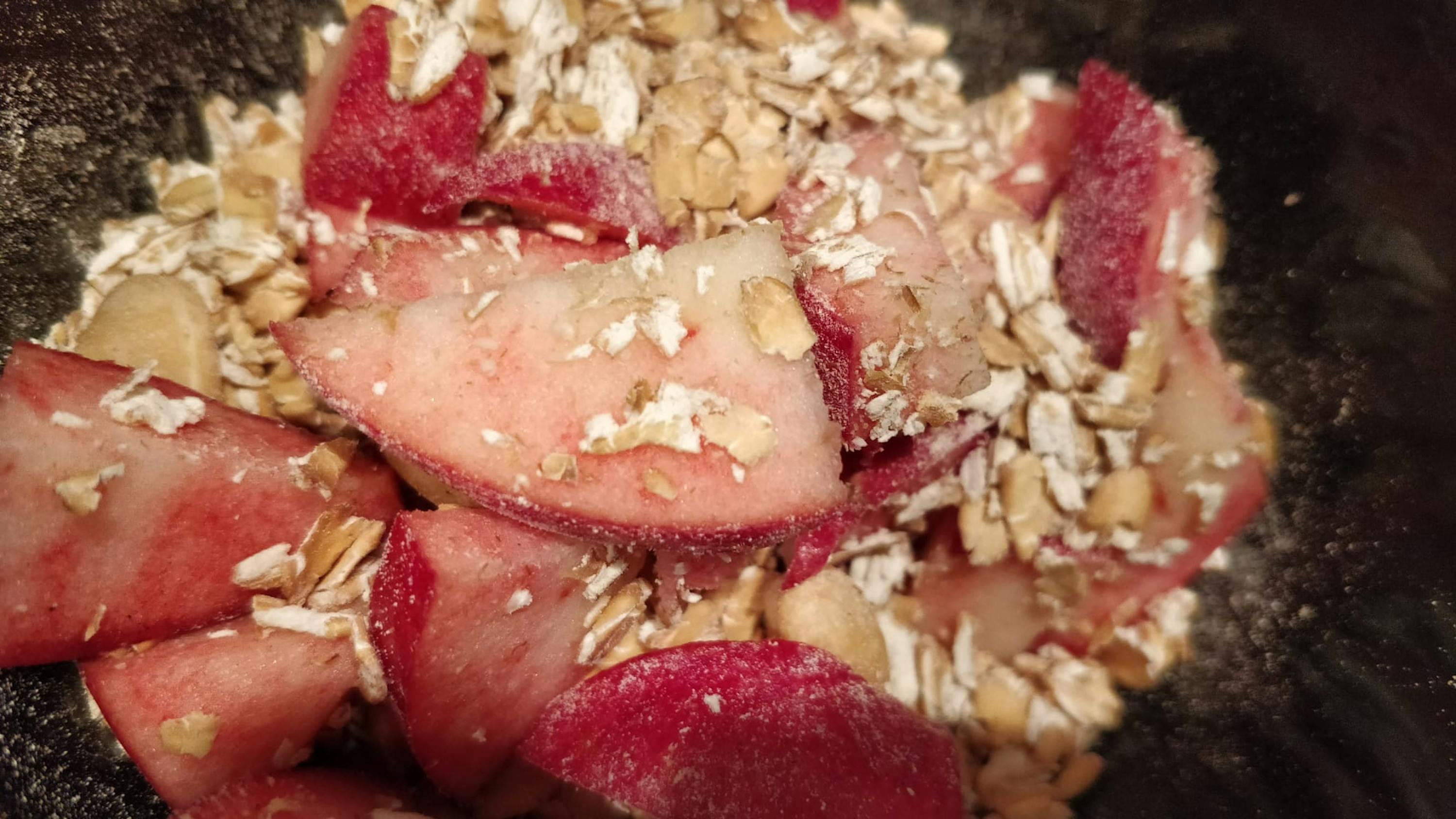 un bol noir rempli d' avoine et de tranches de fruits rouges