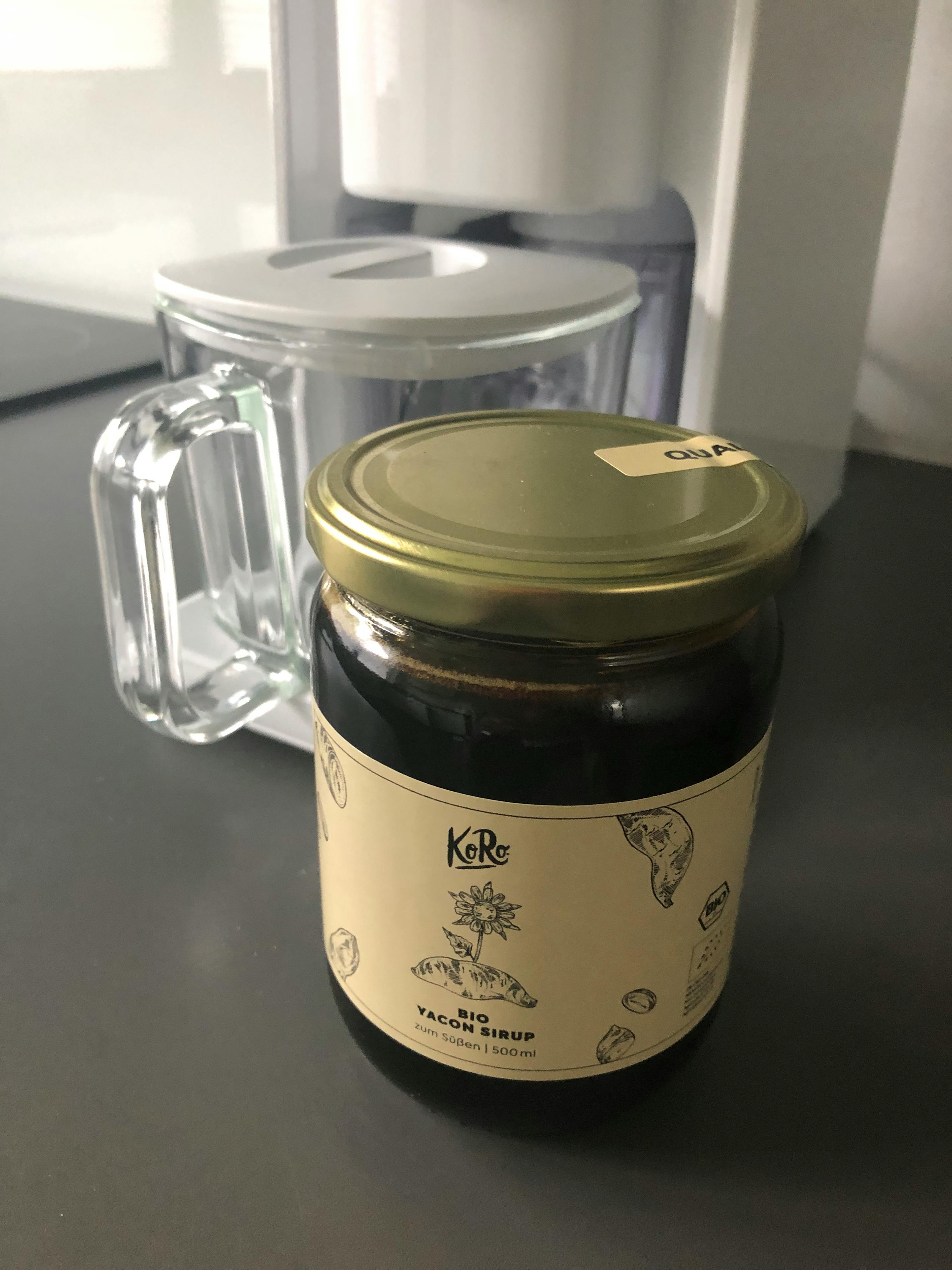 un bocal en verre avec une étiquette à côté d' une tasse en verre