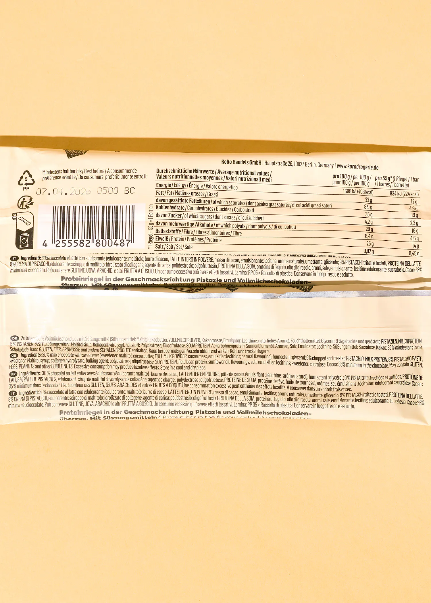 étiquette d'emballage d'une barre protéinée saveur pistache et chocolat au lait, affichant les valeurs nutritionnelles, la liste des ingrédients et la date de péremption.