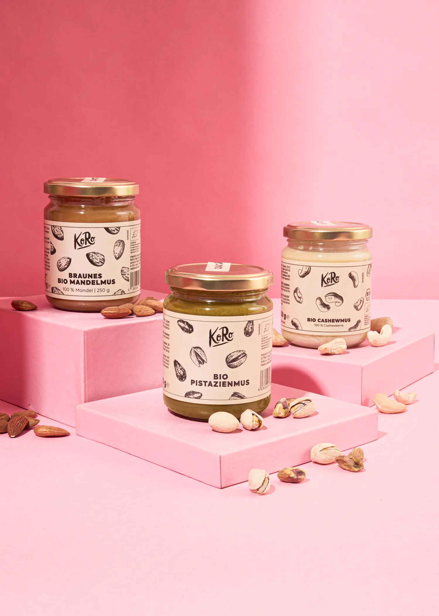 trois bocaux sont posés sur des étagères roses avec des noix dessus