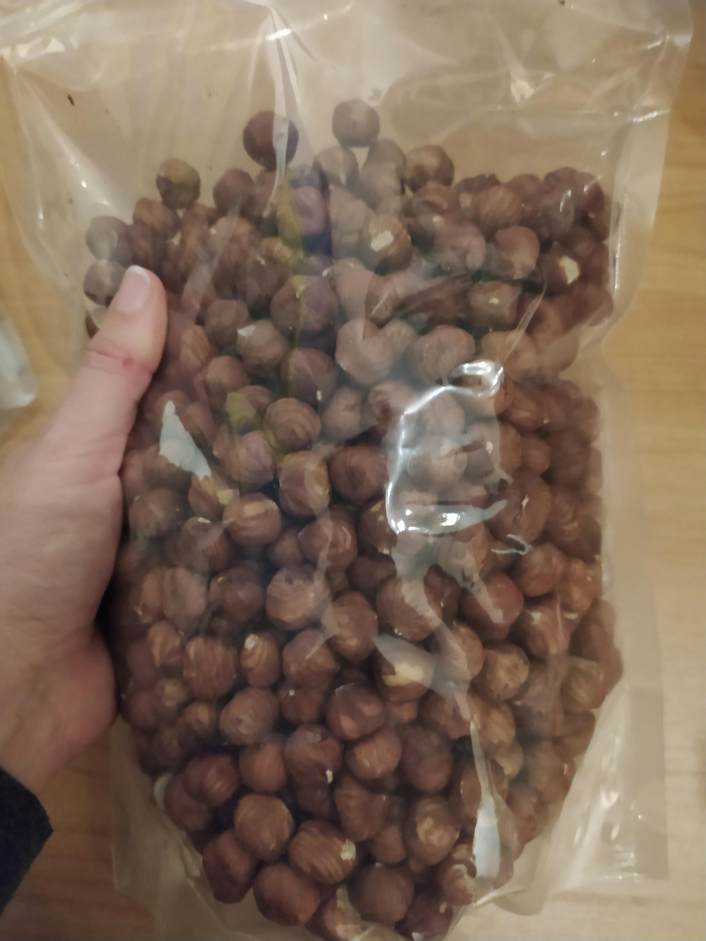 una persona tiene in mano un sacchetto pieno di nocciole