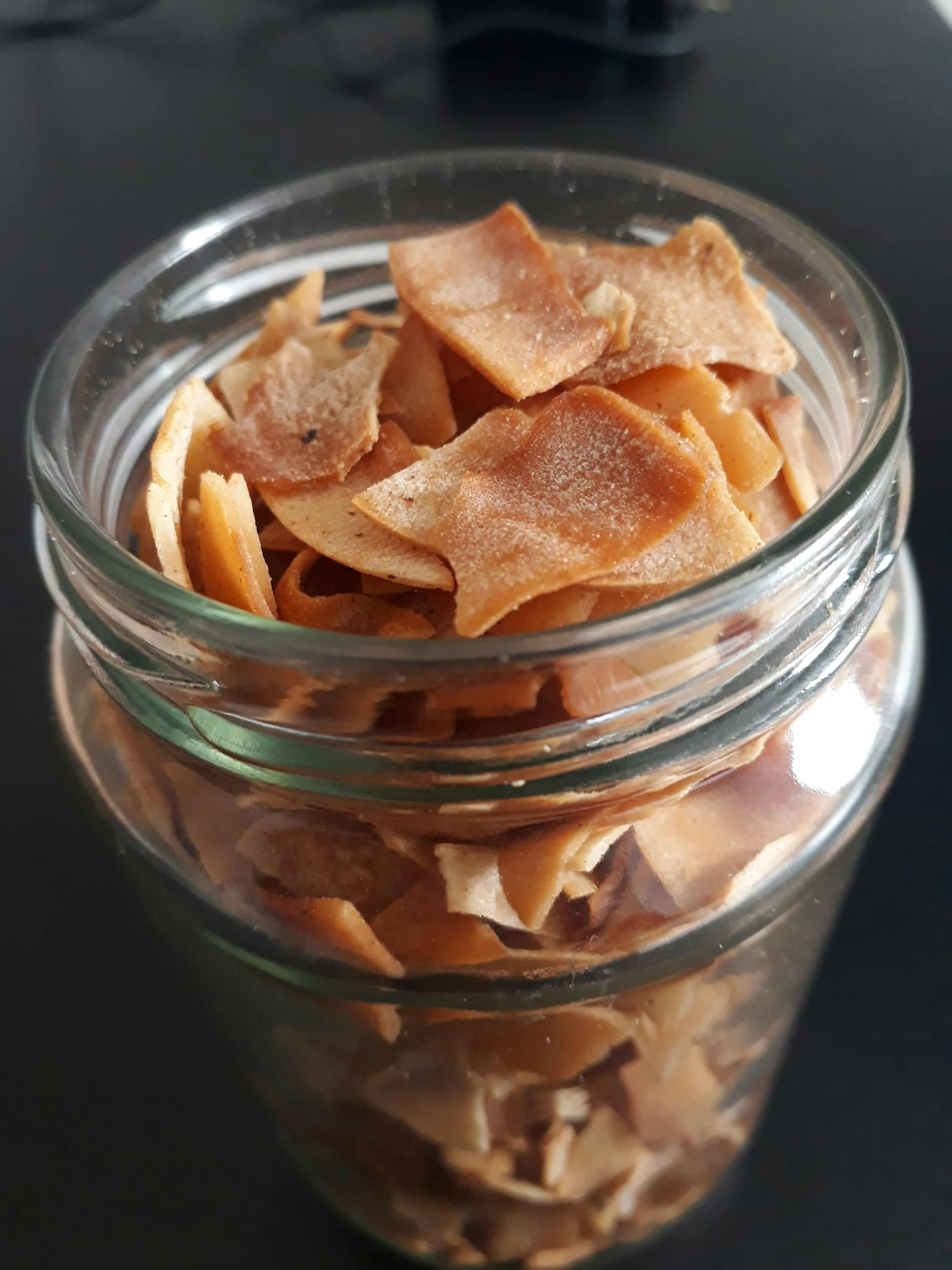 ein Glas gefüllt mit braunen Chips steht auf einem Tisch