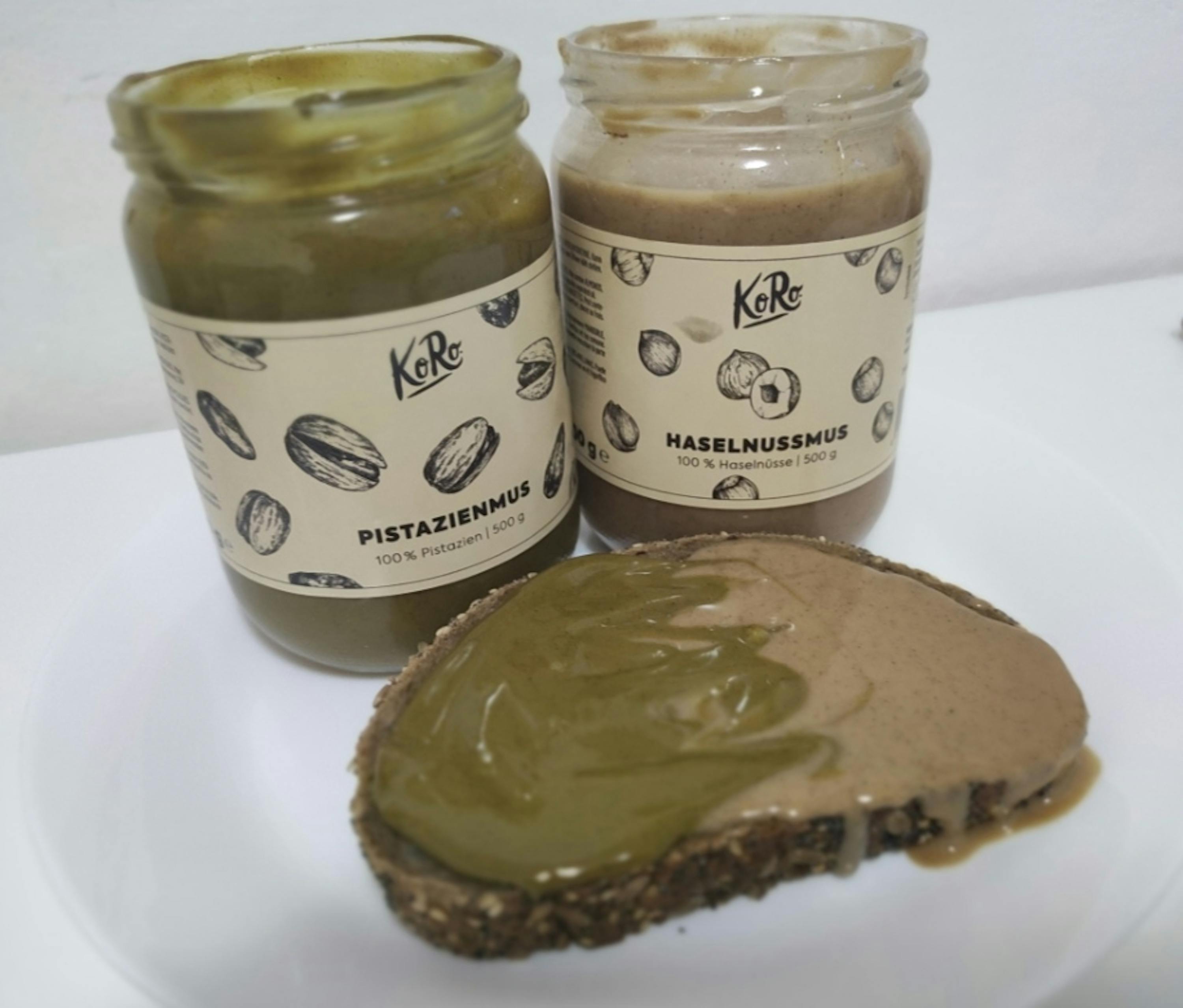 a jar of pistazienmus next to a jar of hazelnusmus