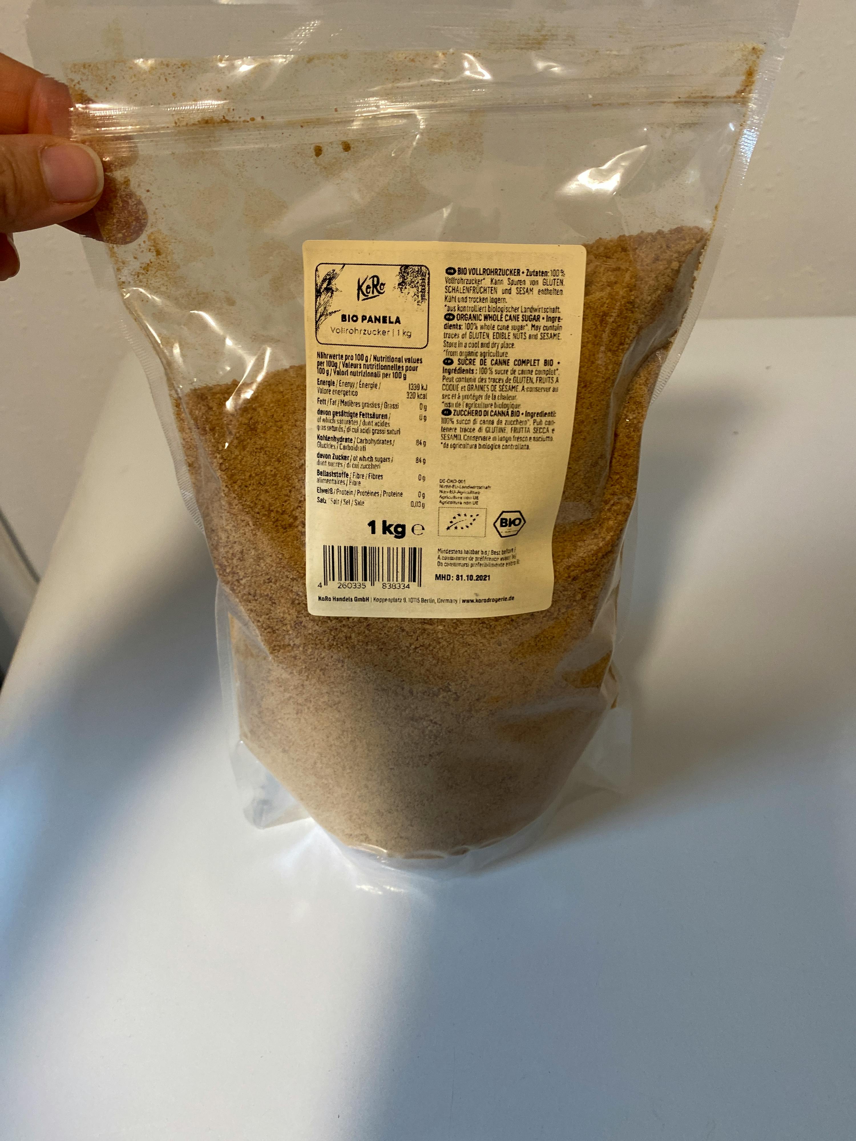 una persona tiene in mano un sacchetto di 1 kg di zucchero