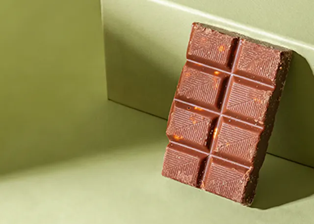 a bar of chocolate is sitting on a green surface