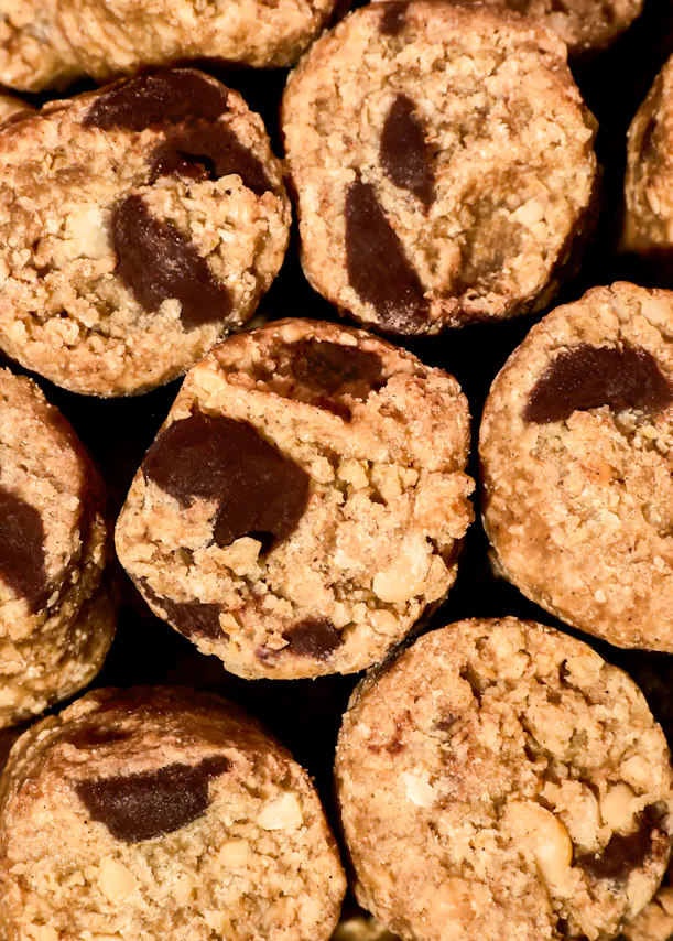 primer plano de galletas redondas con chispas de chocolate y trozos de nueces.