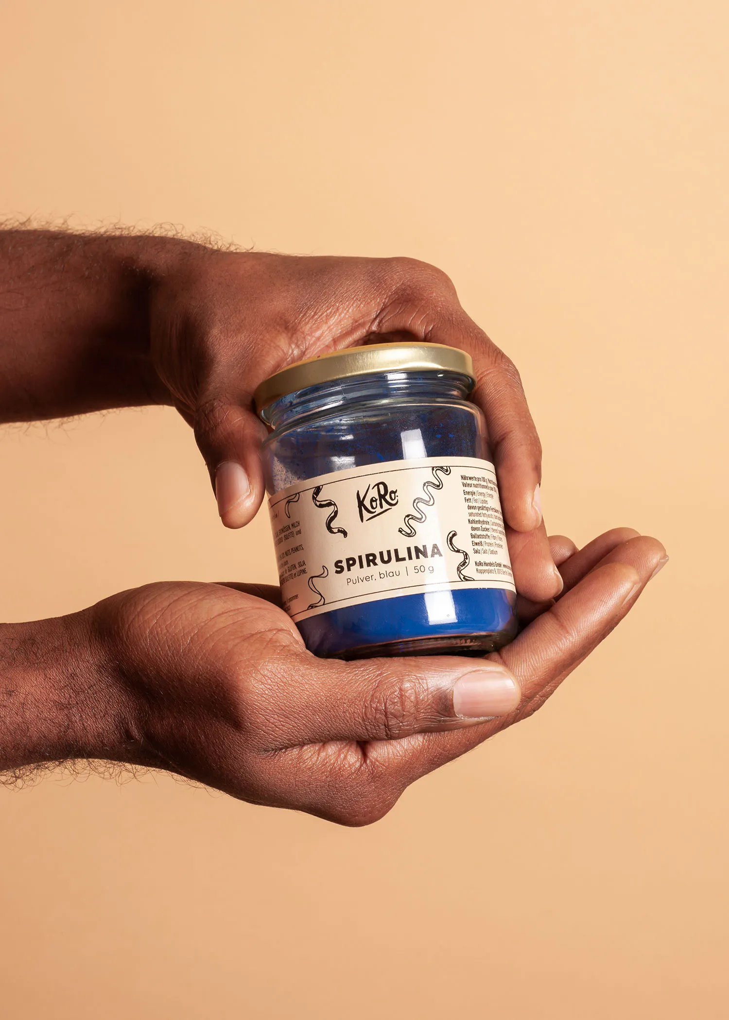 eine Person hält ein Glas spirulina-Pulver in der Hand