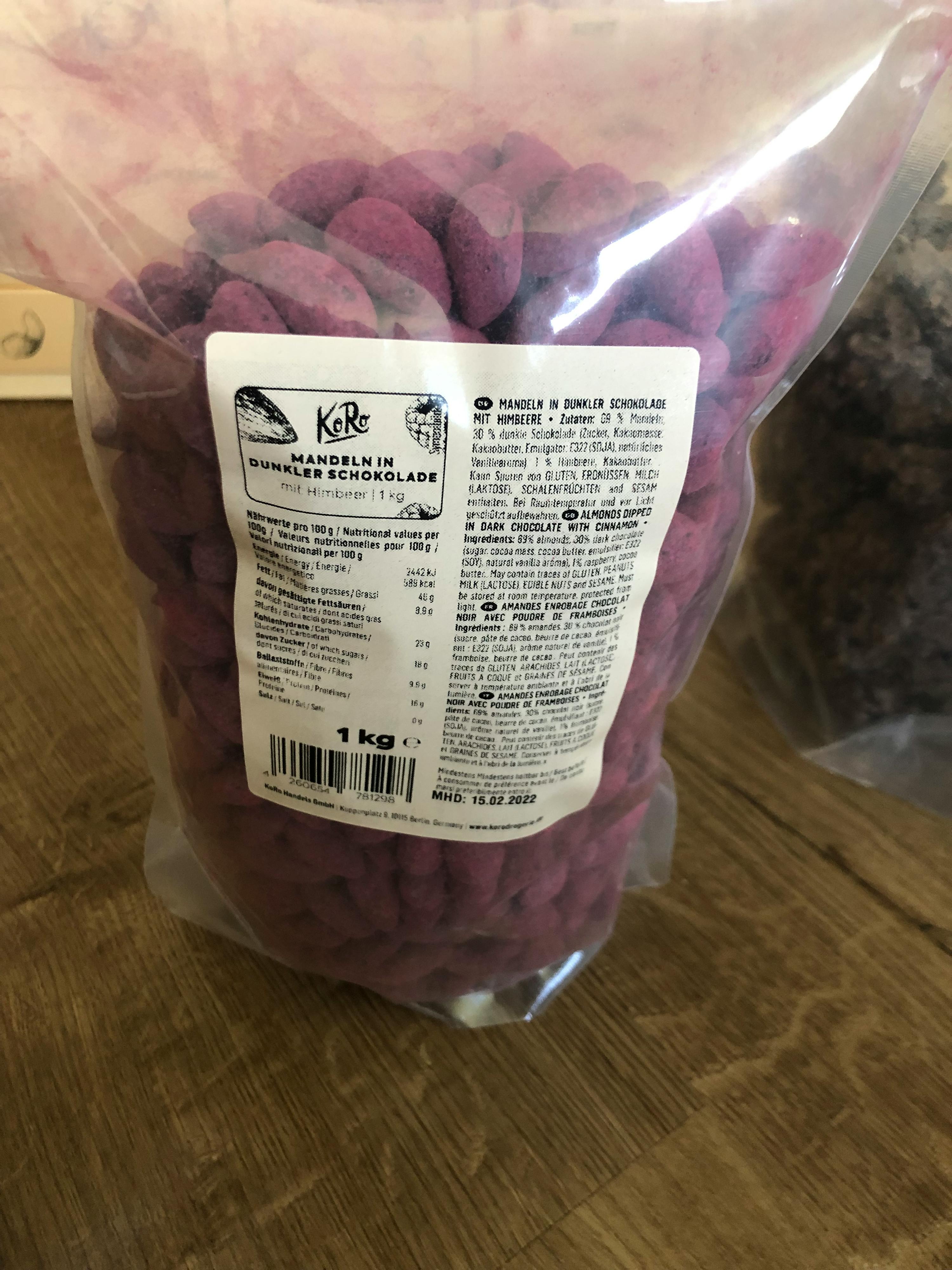 ein Plastikbeutel mit violetten Mandeln steht auf einem Holzboden