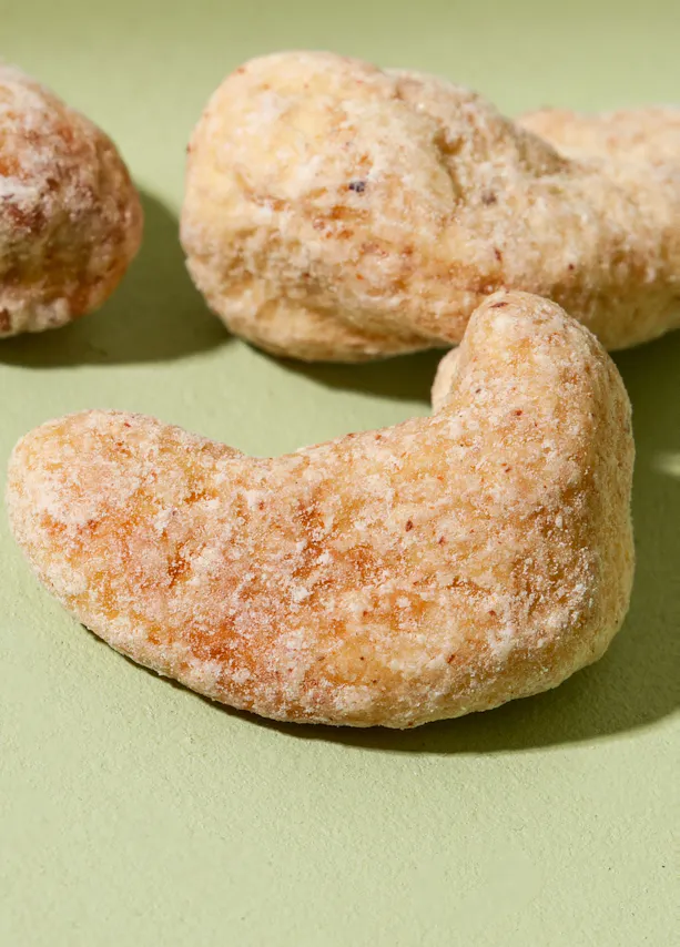 un gros plan d' une noix de cajou sur une surface verte