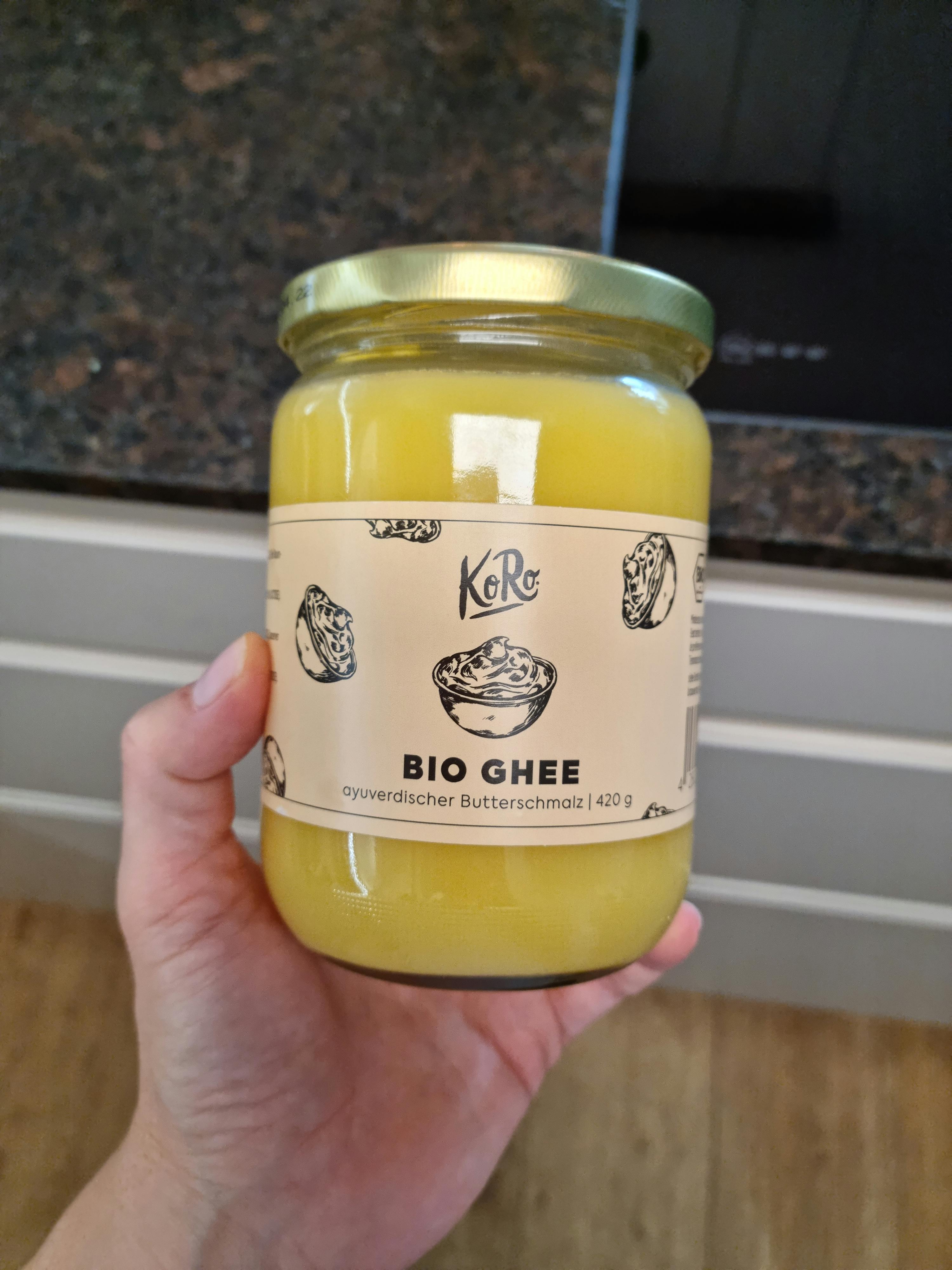 eine Person hält ein Glas Bio-Ghee in der Hand