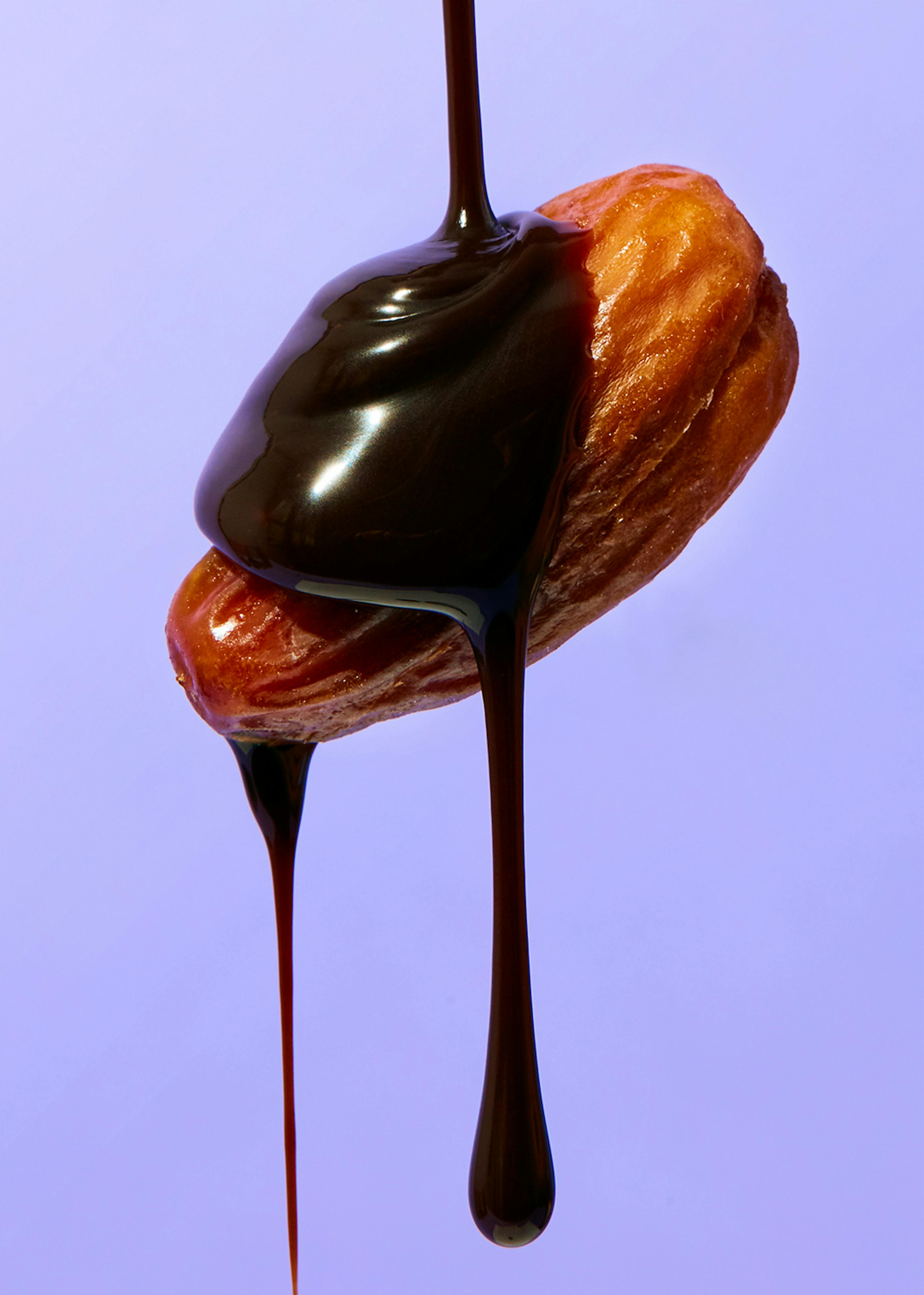 cioccolato viene versato su una noce su sfondo viola